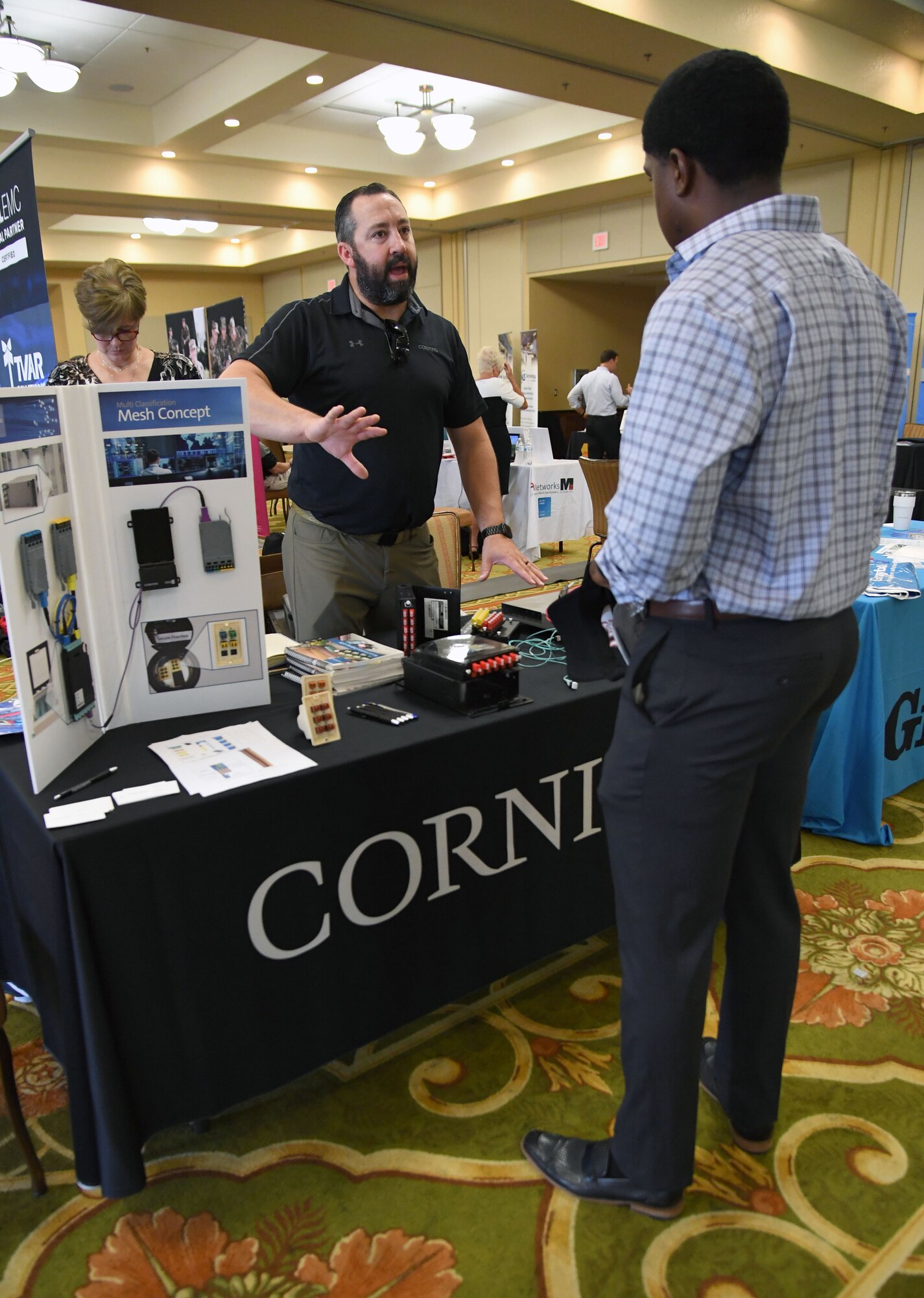 Derek Benson, Corning Optical Communications LLC. sales engineer, briefs equipment capabilities to Dequanze Davis, 338th Training Squadron instructor, during the Technology Expo inside the Bay Breeze Event Center at Keesler Air Force Base, Mississippi, July 15, 2021. The expo, hosted by the 81st Communications Squadron and the Armed Forces Communications and Electronics Association Gulf Coast Chapter, was held to introduce military members to the latest in technological advancements to bolster the Air Force's capabilities in national defense. (U.S. Air Force photo by Kemberly Groue)
