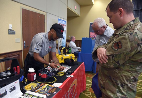 Calvin Lang, Jr., Fiber Instrument Sales Inc. sales associate, provides an equipment demonstration to U.S. Air Force Master Sgt. David Sorensen, 81st Training Support Squadron curriculum developer, and Jonathan Wright, Second Air Force A6 director of operations, during the Technology Expo inside the Bay Breeze Event Center at Keesler Air Force Base, Mississippi, July 15, 2021. The expo, hosted by the 81st Communications Squadron and the Armed Forces Communications and Electronics Association Gulf Coast Chapter, was held to introduce military members to the latest in technological advancements to bolster the Air Force's capabilities in national defense. (U.S. Air Force photo by Kemberly Groue)