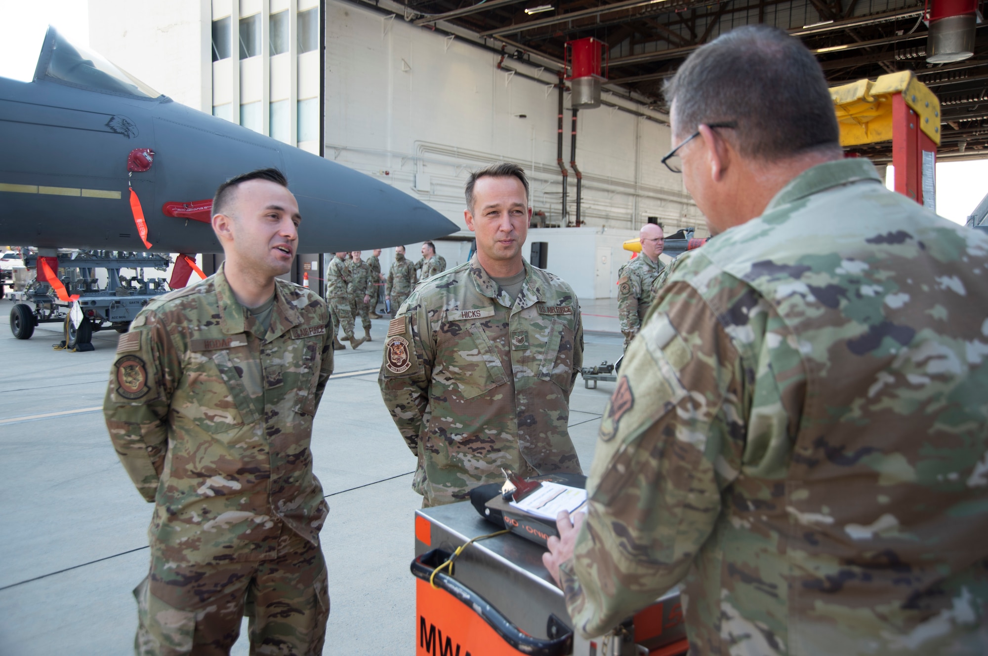 Two Airmen speak with another Airman about their knowledge about the aircraft they are maintaining.