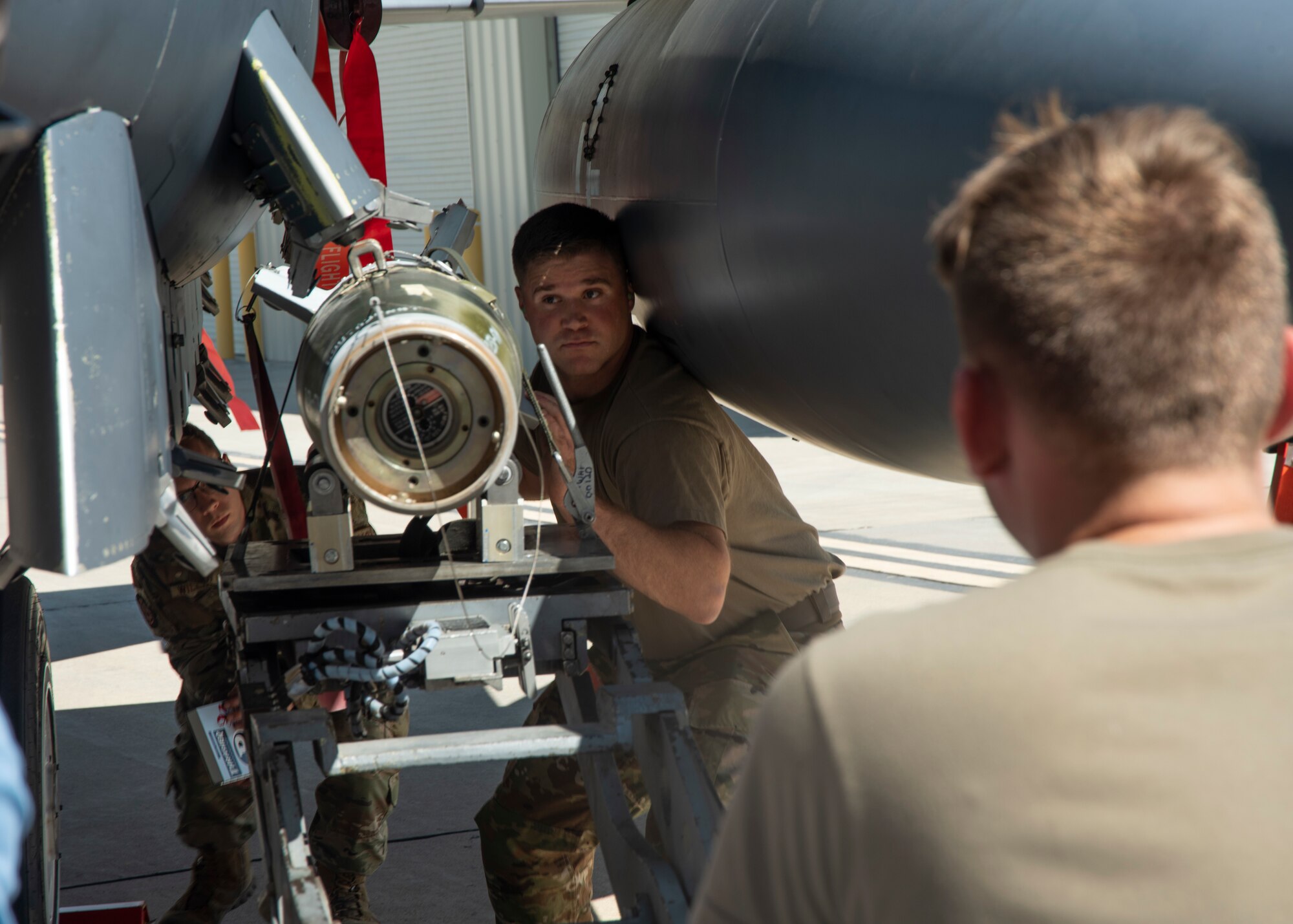 An Airman assist another Airman with loading a Guided Bomb Unit-12 to an F-15E Strike Eagle.