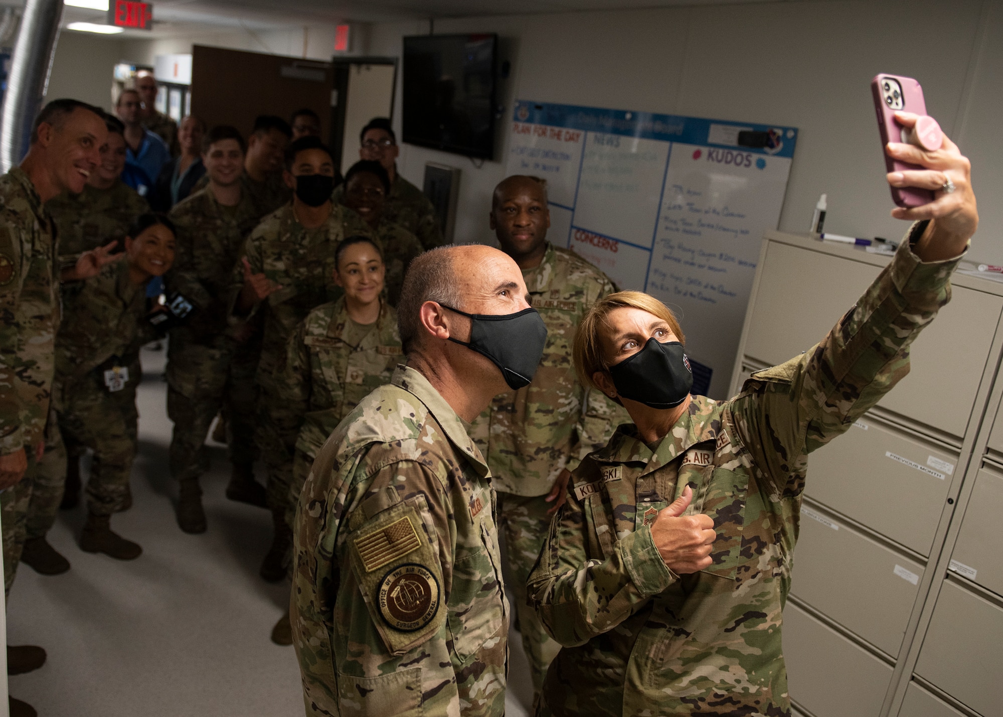 Lt. Gen. Robert Miller, U.S. Air Force and U.S. Space Force surgeon general, and Chief Master Sgt. Dawn Kolczynski, U.S. Air Force and U.S. Space Force chief medical enlisted force, take a photo with personnel assigned to the 99th Medical Group