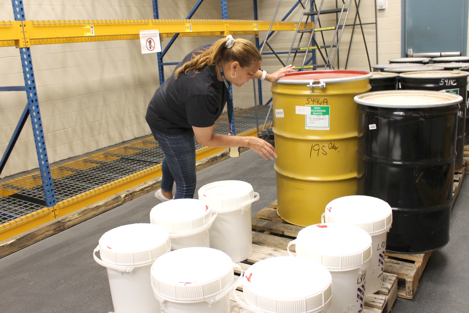 Christina Norman, with the Environmental and Hazardous Waste Operations Group at Arnold Air Force Base, Tenn., checks the label of one of the barrels in the hazardous waste storage facility prior to it being loaded on a truck and taken to the disposal site on June 15, 2021. A current Resource Conservation and Recovery Act Part B permit enables Arnold to store hazardous waste for up to one year at the base’s main storage facility. (U.S. Air Force photo by Deidre Moon)