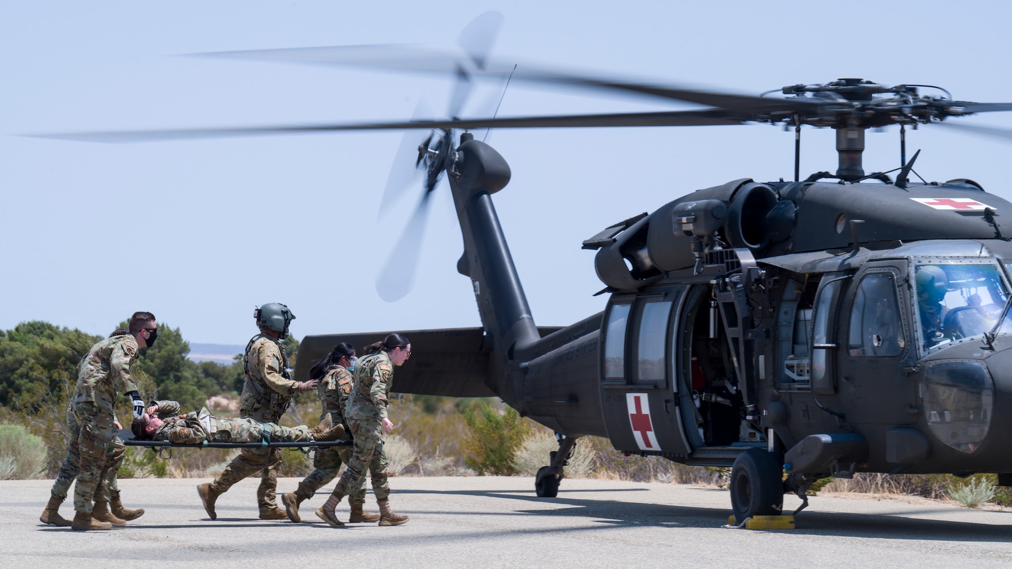 412th Medical Group personnel approach a UH-60 Blackhawk helicoper during a training session at Edwards Air Force Base, California, July 15. Soldiers from C Company, "Desert Dustoff," 2916th Aviation Battalion, 916th Support Brigade, out of Fort Irwin, provided the training to the Edwards AFB Airmen. (Air Force photo by Giancarlo Casem)