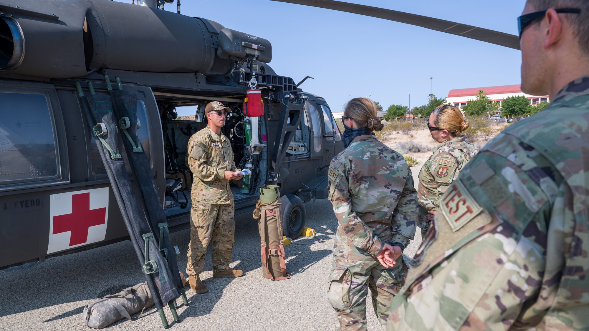 Staff Sgt. Deric Randol, a flight medic with C Company, "Desert Dustoff," 2916th Aviation Battalion, 916th Support Brigade, out of Fort Irwin, trains members of the 412th Medical Group on proper patient loading procedures during a training session at Edwards Air Force Base, California, July 15. (Air Force photo by Giancarlo Casem)