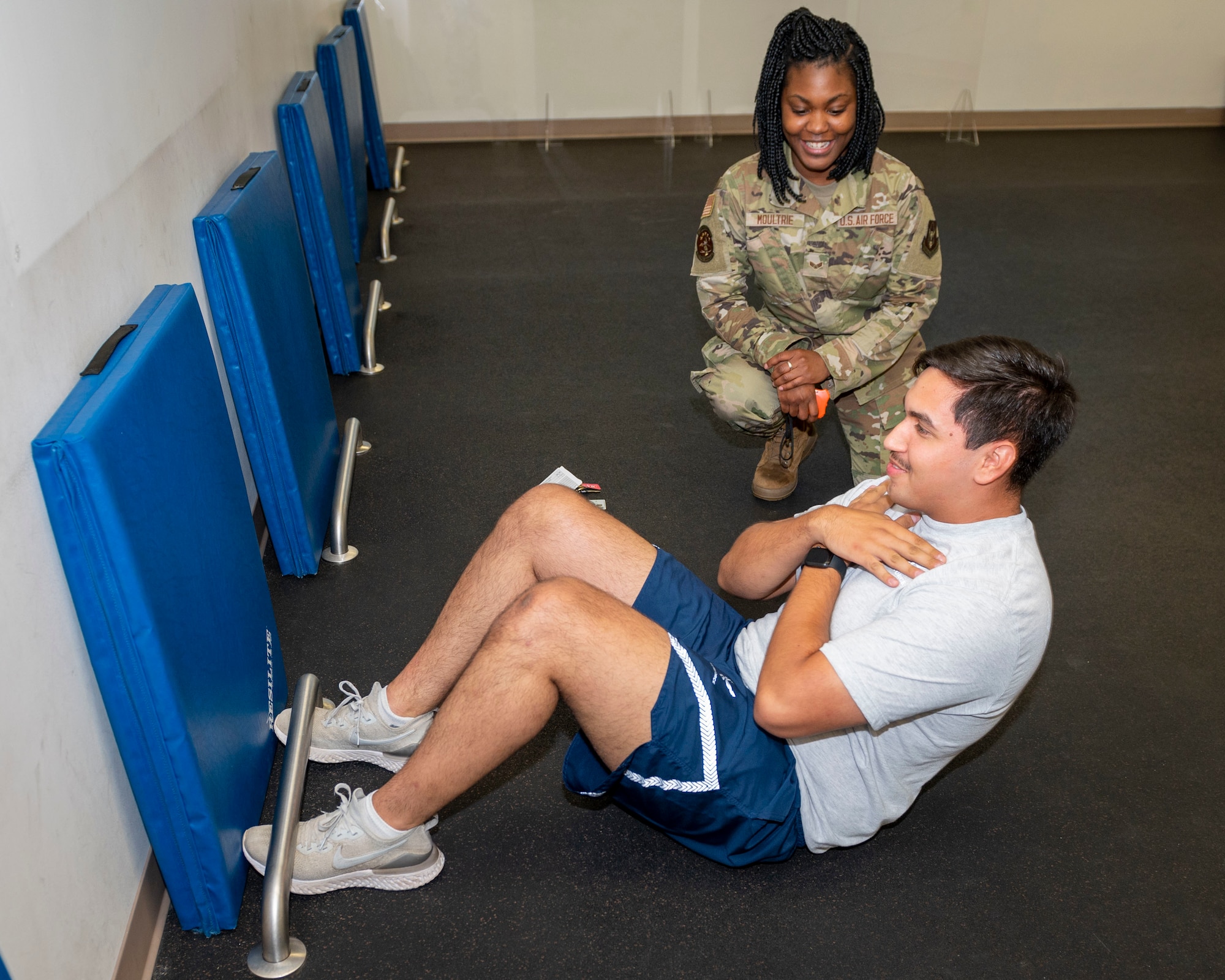 Senior Airman Kevin McMahon, 333rd Fighter Squadron weapons load crew member, performs sit-ups while Senior Airman Deja Moultrie, 916th Force Support Squadron service technician counts his repetitions at Seymour Johnson Air Force Base, North Carolina, July 15, 2021.
