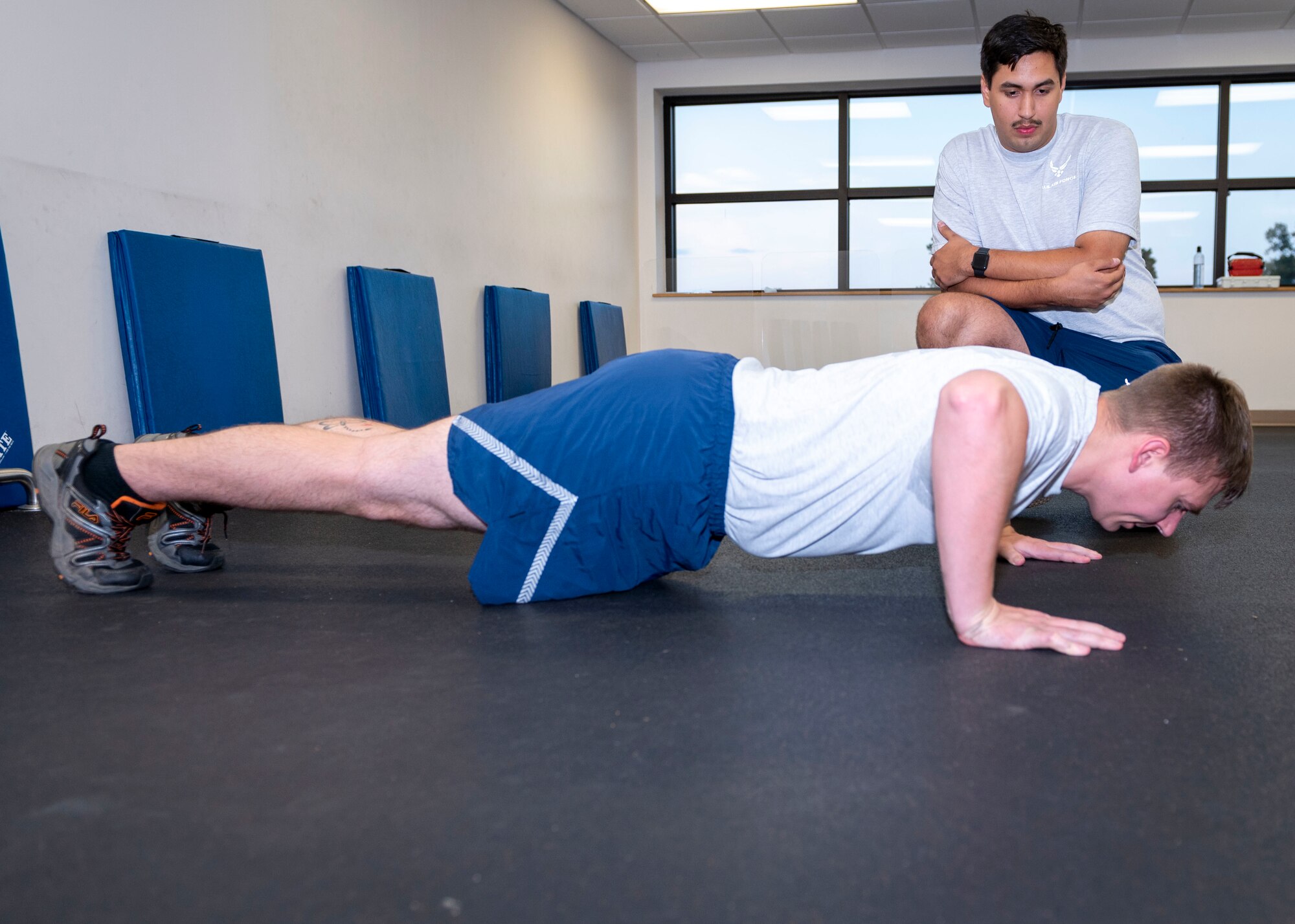 Tech. Sgt. Daniel Parker, 4th Equipment Maintenance Squadron phase and avionics NCO in charge and dock chief, performs push-ups while Senior Airman Kevin McMahon, 333rd Fighter Squadron weapons load crew member, counts his repetitions at Seymour Johnson Air Force Base, North Carolina, July 15, 2021.