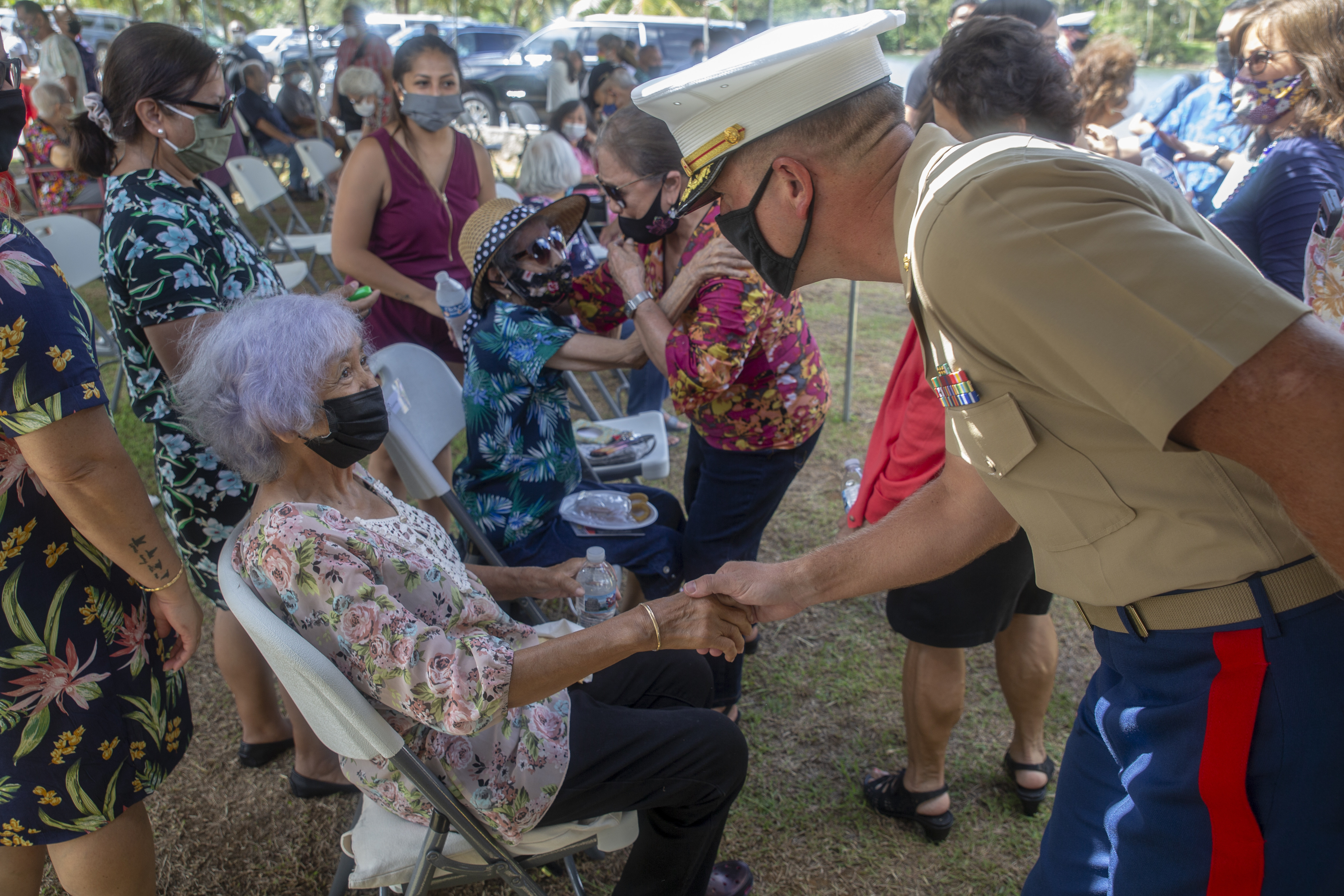 Maj. Tyler Ford, the Marine Corps Base (MCB) Camp Blaz Logistics Officer, greets a World War II survivor during a memorial service in Inalåhan, Guam, July 15, 2021.