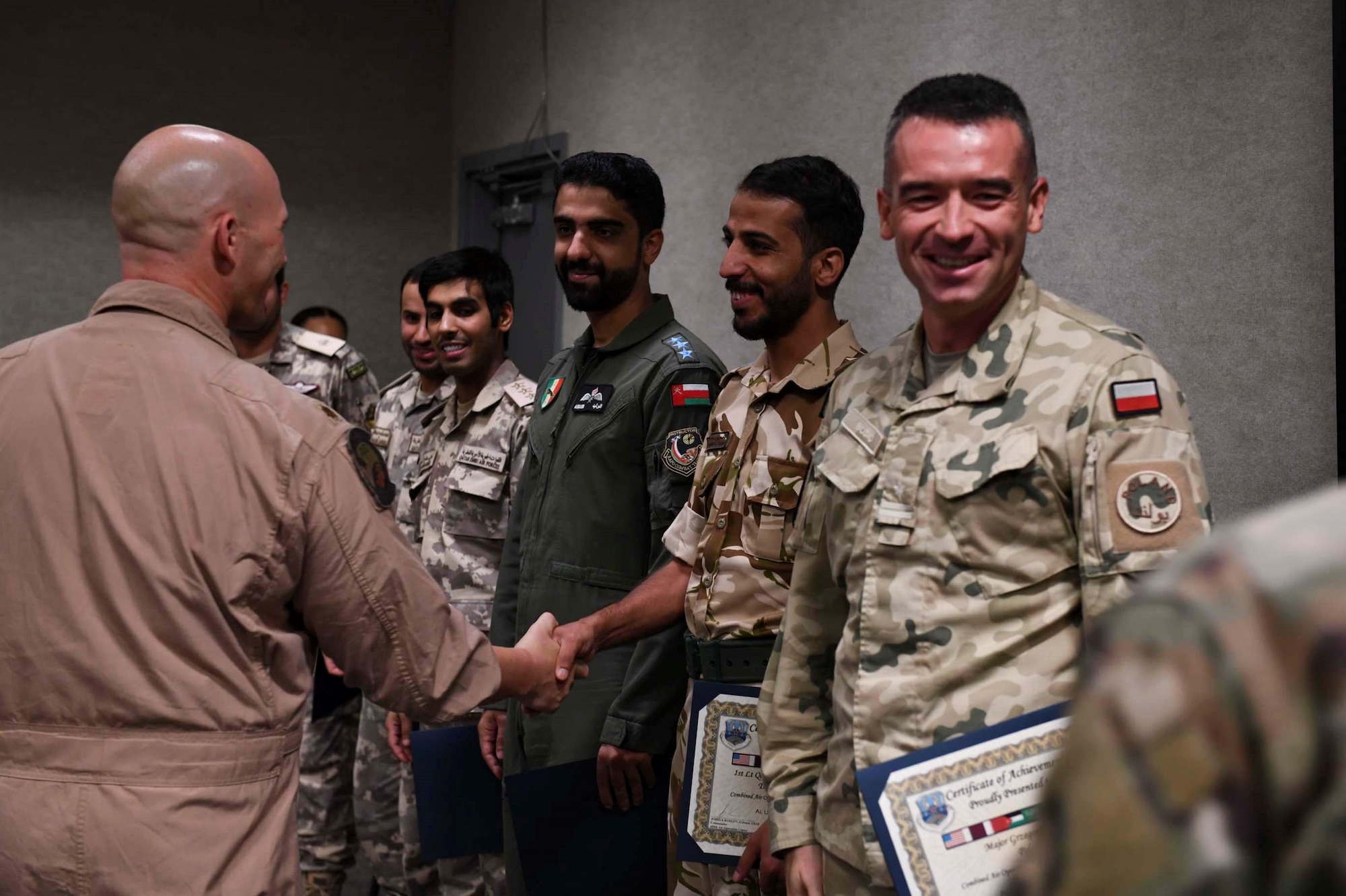 New graduates of the Air Defense Liaison Officer Course celebrate after a commencement ceremony at the Combined Air and Space Operations Center, June 24, 2021, Al Udeid Air Base, Qatar. Through a mix of academics, practical exercises, and simulations, the course teaches students to lead a CAOC mission in their home countries, or to return to the AFCENT CAOC as a fully-integrated liaison officer. (U.S. Air Force photo by Staff Sgt. Alexandria Lee)