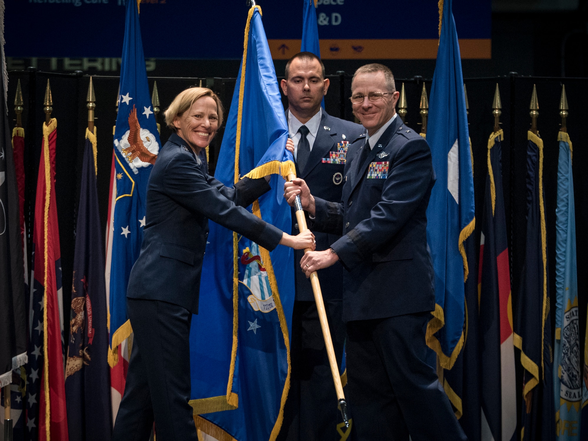 Maj. Gen. Heather Pringle, Air Force Research Laboratory commander, passes the 711th Human Performance flag to Brig. Gen. (Dr.) John Andrus during an assumption of command ceremony July 19, 2021 at the National Museum of the U.S. Air Force. (U.S. Air Force photo by Richard Eldridge)