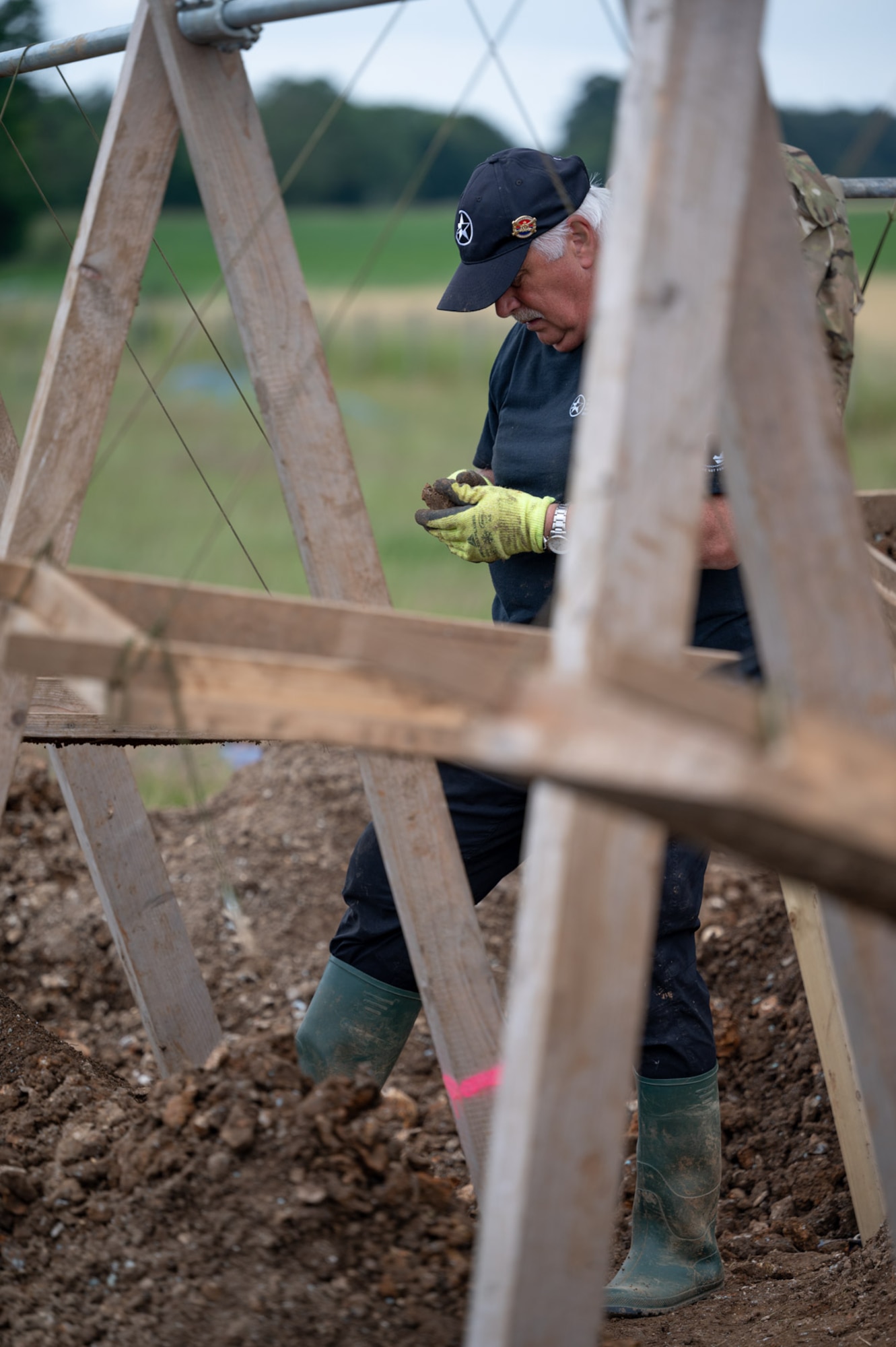 Peter Hay, retired British Army soldier and volunteer with American Veterans Archaeological Recovery group, separates dirt and clay while trying to recover the remains of an aircrew from a World War II era B-24 Liberator crash site at Park Farm, Arundel, England, July 8, 2021. The team was comprised of around 20 volunteers from local universities, veterans from both United States and British armed forces, and active duty service members from RAF Lakenheath. (U.S. Air Force photo by Senior Airman Koby I. Saunders)