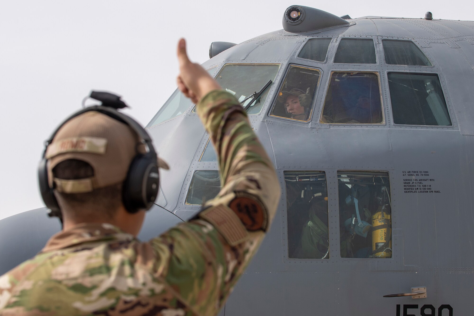 Airman giving thumbs up to pilot in EC-130H prior to taking off