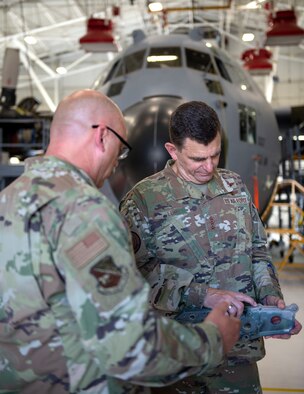 U.S. Air Force Senior Master Sgt. Bradley Dahl, left, 133rd Maintenance Squadron, shows Lt. Gen. Michael A. Loh, director, Air National Guard, a carriage part from a C-130 Hercules in St. Paul, Minnesota, July 17, 2021.