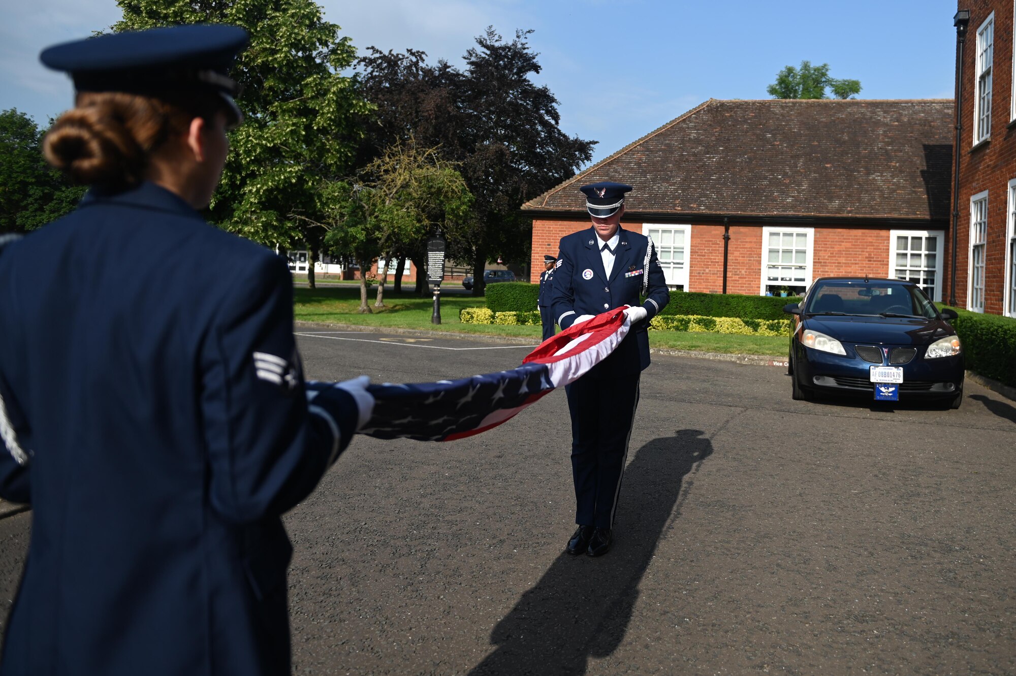 Members from the 100th Air Refueling Wing honor guard prepare to fold a flag at Royal Air Force Mildenhall, England, July 19, 2021. The honor guard folded the flag to present to the Col. Troy Pananon on his last day as the 100th Air Refueling Wing commander. (U.S. Air Force photo by Staff Sgt. Matthew J. Wisher)
