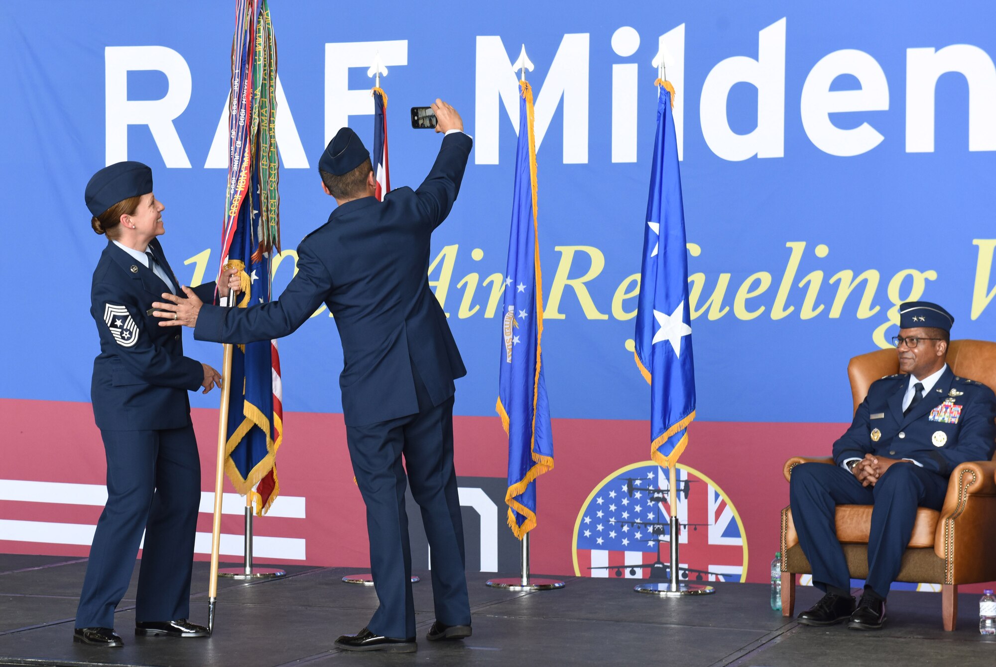 U.S. Air Force Col. Troy Pananon, center, former 100th Air Refueling Wing commander, and Chief Master Sgt. Kathi Glascock, left, 100th ARW command chief, take a selfie at the 100th ARW change of command ceremony at Royal Air Force Mildenhall, England, July 19, 2021. Pananon relinquished command to Col. Gene Jacobus. (U.S. Air Force photo by Karen Abeyasekere)