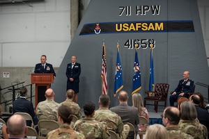 Brig. Gen. John Andrus, 711th Human Performance Wing commander, speaks about the family support and career of Col. Tory Woodard, the new United States Air Force School of Aerospace Medicine commander, during an assumption of command ceremony July 19, 2021 in the school’s high bay. USAFSAM is one of two mission units in the Air Force Research Laboratory’s 711th Human Performance Wing. (U.S. Air Force photo/Richard Eldridge)