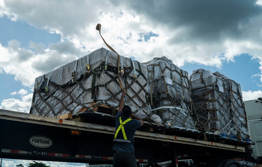 U.S. Air Force personnel and Surinamese locals unload field hospital equipment at Johan Adolf Pengel International Airport, Suriname, July 16, 2021.