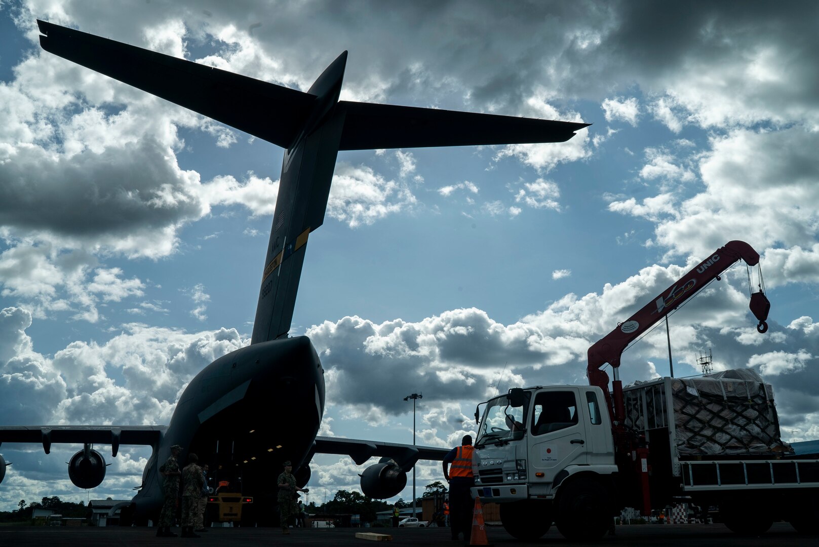 U.S. Air Force personnel and Surinamese locals unload field hospital equipment at Johan Adolf Pengel International Airport, Suriname, July 16, 2021.