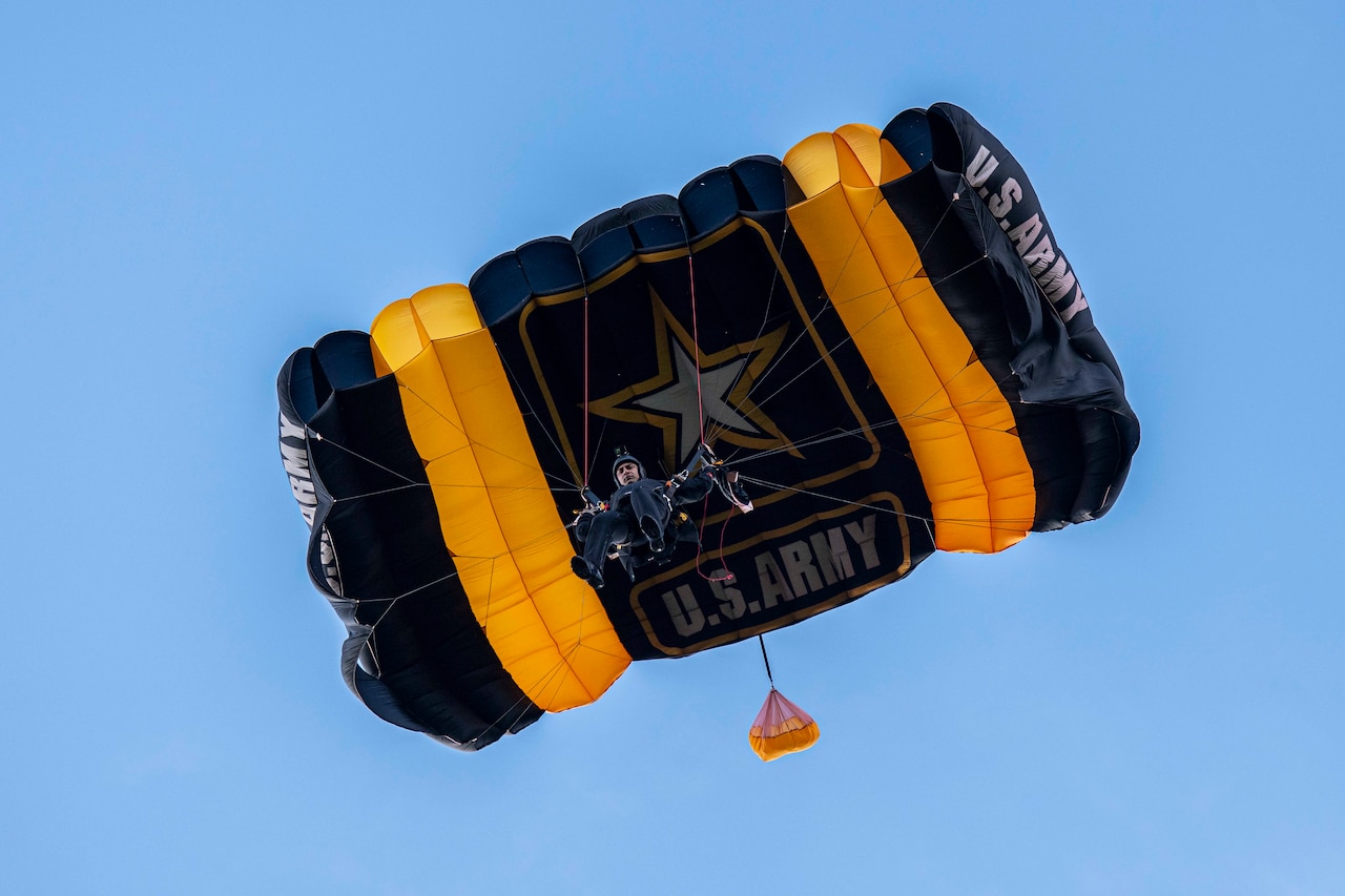A soldier freefalls with a parachute.