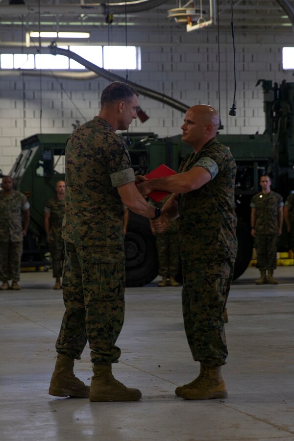 U.S. Marine Corps Gunnery Sgt. Adam Plambeck, right, a native of Stafford, Va., and a maintenance chief with 1st Battalion, 10th Marine Regiment, 2d Marine Division (MARDIV), receives the Motor Transport Maintenance Chief of the Year from Maj. Gen. Francis Donovan, commanding general of 2d MARDIV, at Camp Johnson, N.C., July 19, 2021.