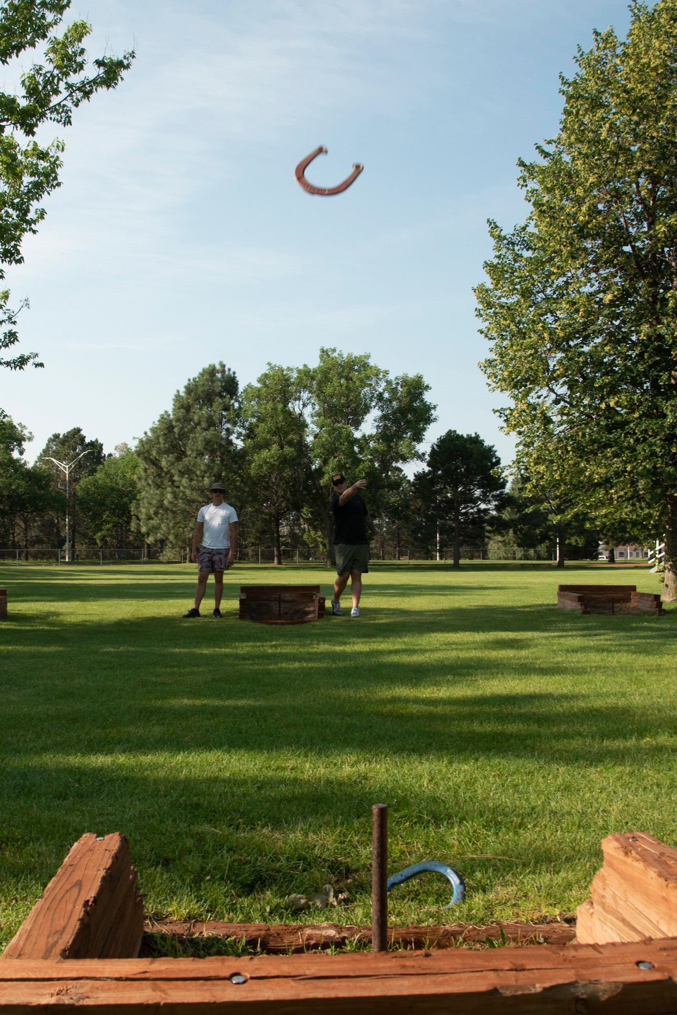 U.S. Air Force Tech. Sgt. Ryan Payne, right, and U.S. Air Force Staff Sgt. Codie Sechi both with the 561st Network Operations Squadron play horseshoes during Sports and Field Day at Peterson Air Force Base, Colorado, July 16, 2021.  The Sports and Field Day included a variety of physical and mental activities, food and prizes. (U.S. Space force photo by Airman Aaron Edwards)