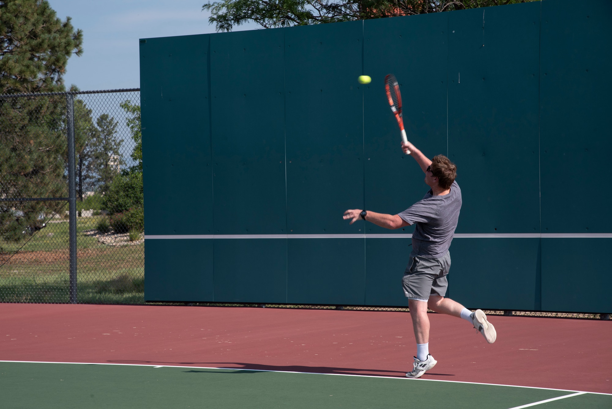 Philip Patton with the U.S. Army Space and Missile Defense Command plays tennis during Sports and Field Day at Peterson Air Force Base, Colorado, July 16, 2021. Other activities hosted during the Peterson AFB Sports and Field Day included soccer, basketball, flag football, horseshoes and volleyball. (U.S. Space force photo by Airman Aaron Edwards)