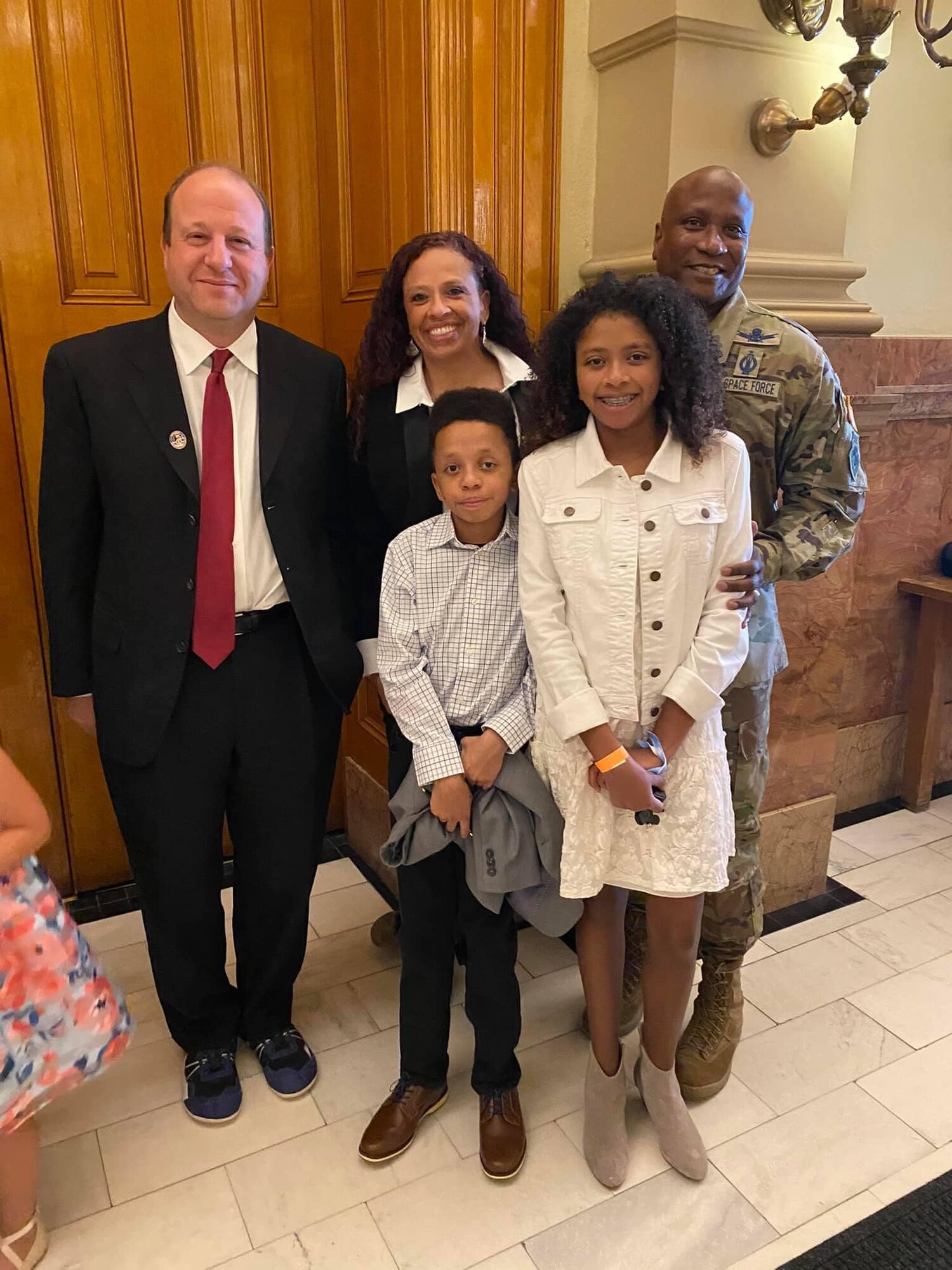 The Pepper family and Colorado governor pose for a photo in Denver.