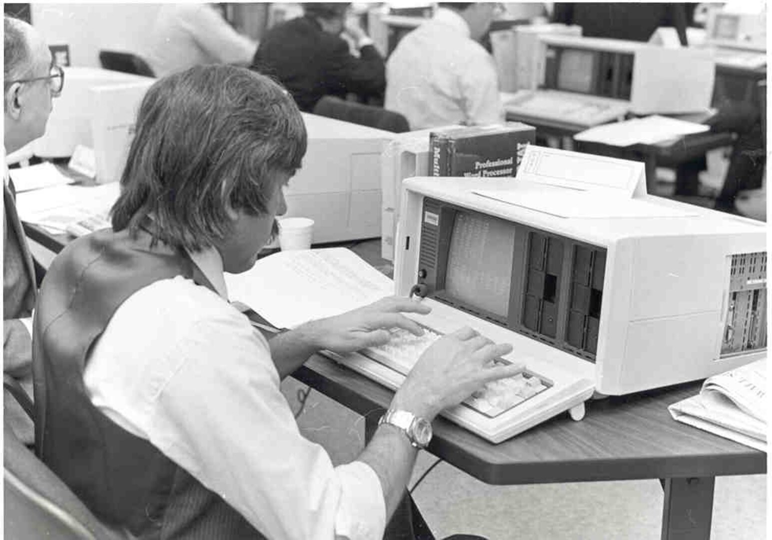 man in front of early computer with dual floppy disc drives