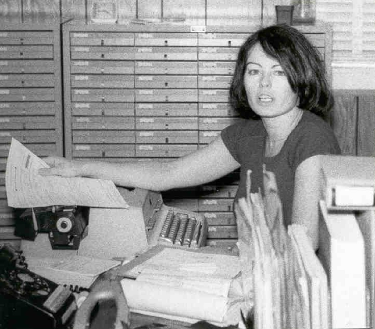 woman in front of typewriter looking overworked