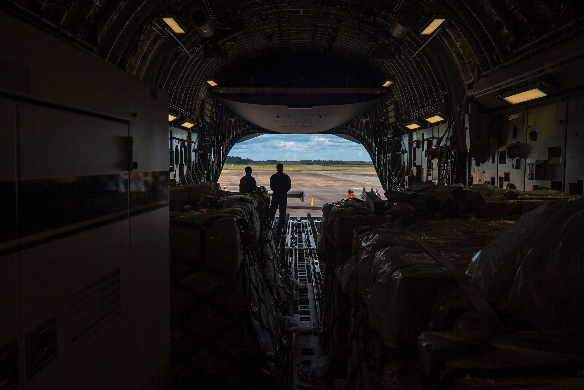 U.S. Air Force personnel and Surinamese locals unload field hospital equipment at Johan Adolf Pengel International Airport, Suriname, July 16, 2021.