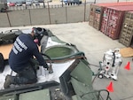 Corrosion Service Team member Alberto Ramirez using the portable vacuum blast system as part of the Amphibious Assault Vehicle Common Remotely Operated Weapons Station Modification project in Camp Pendleton, Calif., in May 2021.