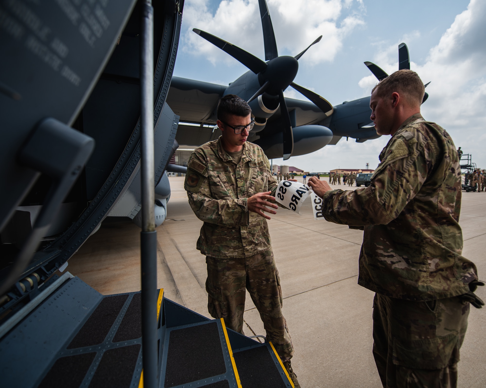 27th Special Operations Wing Airmen prepare a stencil for the wing’s new AC-130J Ghostrider gunship at Cannon Air Force Base, NM, July 19, 2021. The arrival of Cannon’s AC-130J represents a significant expansion of AC-130 capacity as AFSOC structures for the future of Special Operations force generation models as Air Commandos adapt to near-peer power competition throughout global operations. (U.S. Air Force photo by Staff Sergeant Candin Muniz) (This photo has been altered for security purposes by blurring out squadron identifiers and nametapes)