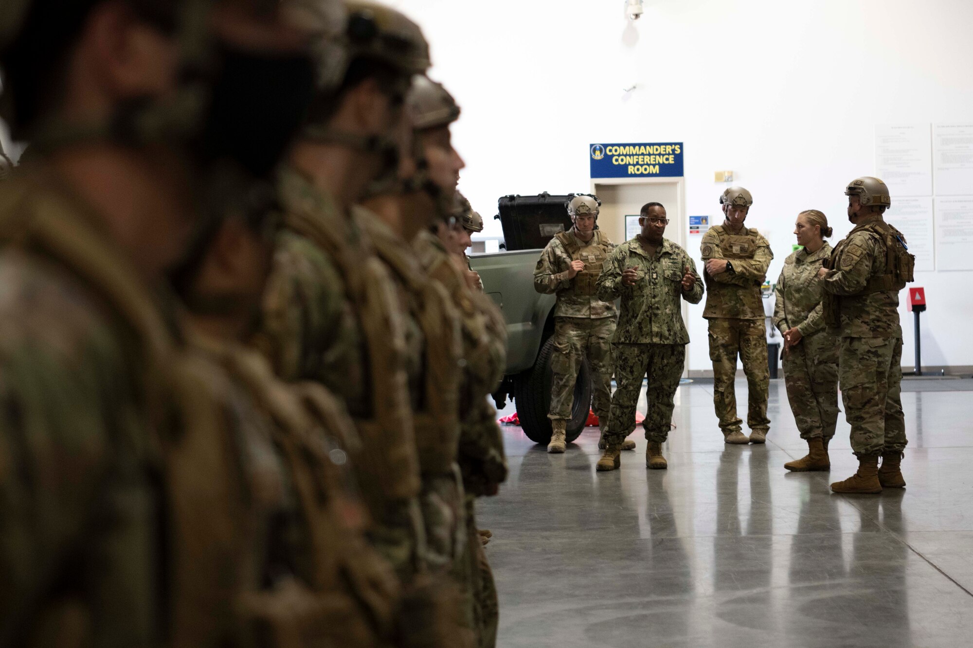 a group of people standing and talking in a warehouse