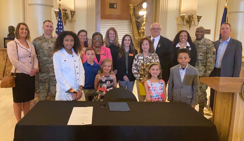 Colorado military families and state lawmakers pose for a photo in Denver.