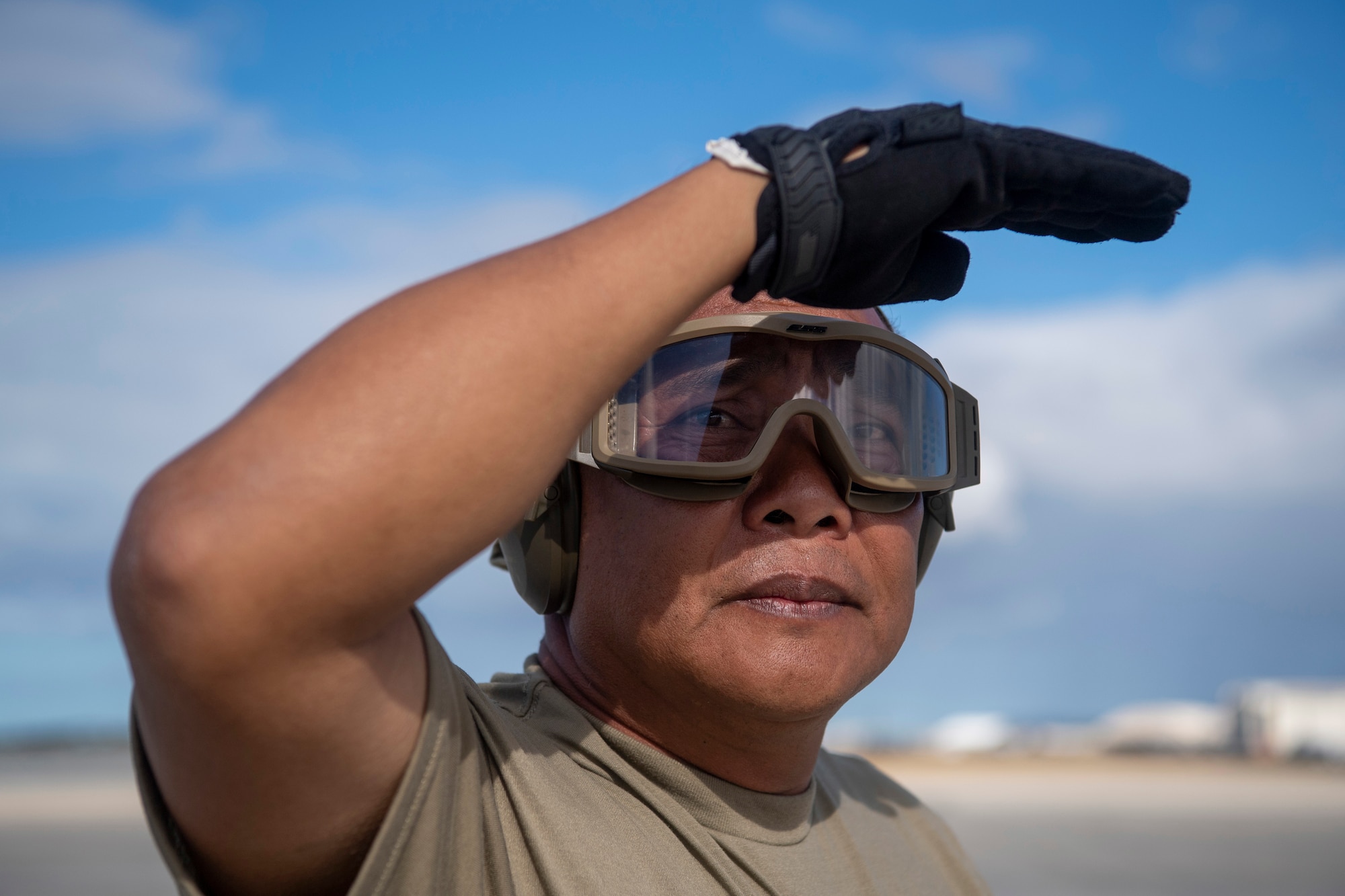 Senior Airman Rogelio Estabillo, 48th Aerial Port
Squadron's pivot man, directs cargo and personnel during
an Engine Running Onload/Offload (ERO) exercise 
while at Joint Base Pearl-Harbor-Hickam June 13, 2021.