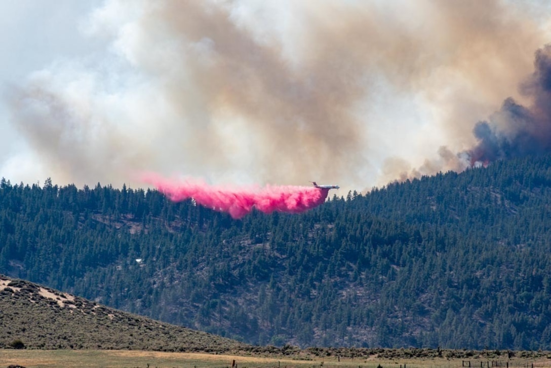 A civilian air tanker drops retardant on the Beckwourth Complex Fire July 9, 2021 near Frenchman Lake in N. California.