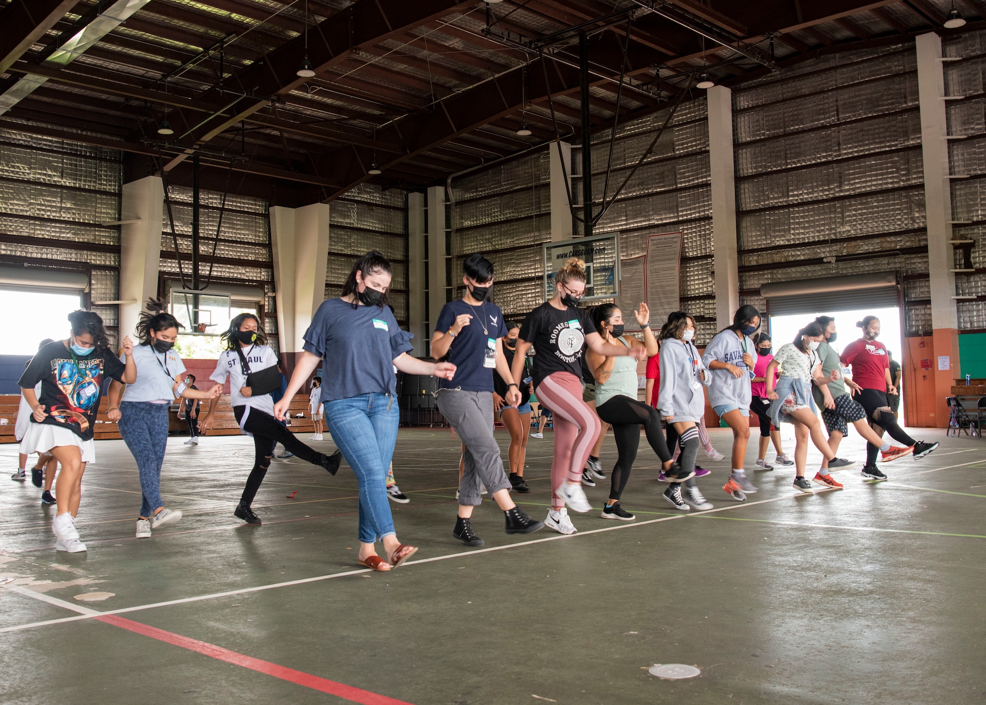 U.S. Air Force Airmen from the 36th Wing, Wing Staff Agency dance with middle and high school students during a mentoring volunteer event at Astumbo Middle School in Dededo, Guam, July 19, 2021. The Airmen volunteered through their Sister Village Sister Squadron program, which partnered with Mañe'lu, an organization with a mission to empower and educate children and families facing adversity to change their lives for the better. (U.S. Air Force photo by Senior Airman Aubree Owens)