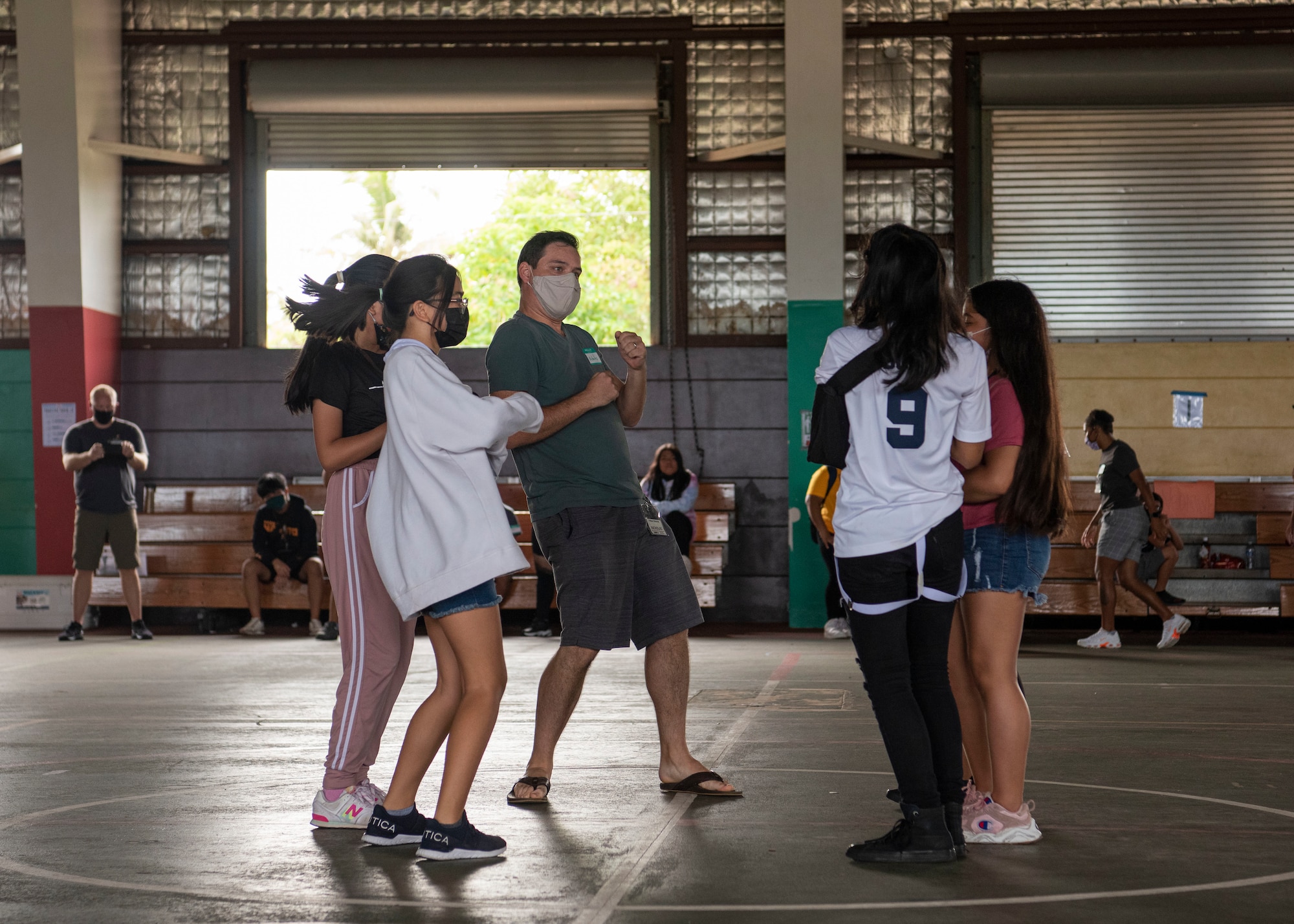 U.S. Air Force Staff Sgt. Nicholas Crisp, Mañe'lu volunteer, creates and performs a handshake dance with his group during a mentoring volunteer event at Astumbo Middle School in Dededo, Guam, July 19, 2021. Crisp and the other volunteers spent four hours with their small groups, getting to know one another and bonding during planned activities. (U.S. Air Force photo by Senior Airman Aubree Owens)