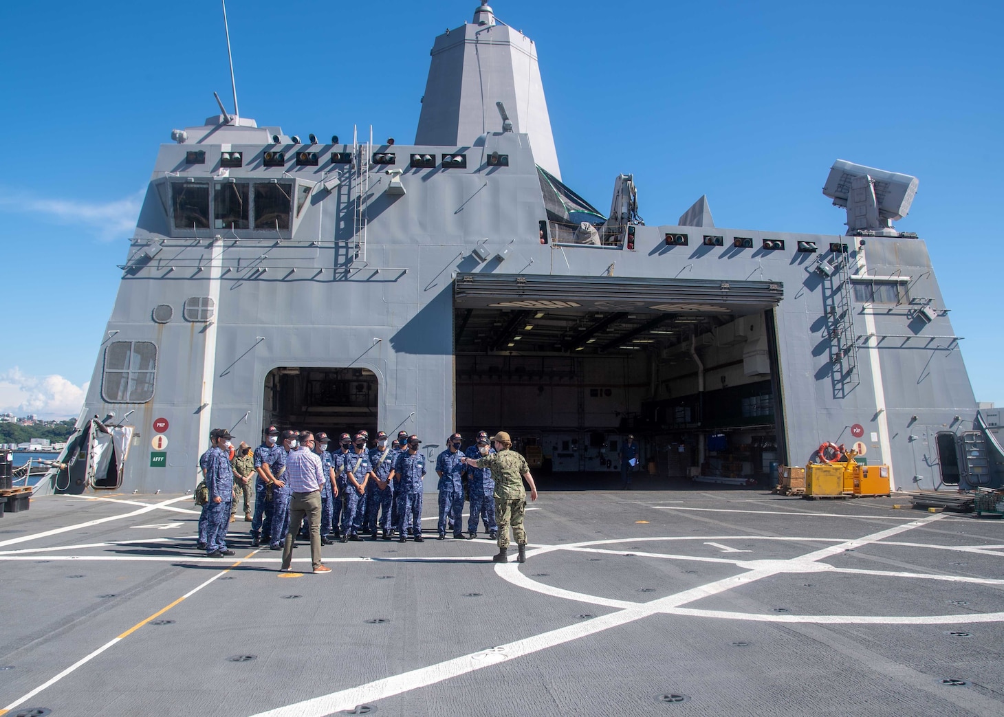 Lt. j.g. Monica Sullivan, assigned to the amphibious transport dock ship USS Green Bay (LPD 20), guides National Defense Academy of Japan cadets during a ship tour aboard the ship July 14, 2021. During their visit to Commander, Fleet Activities Sasebo (CFAS), the cadets toured CFAS facilities and visited Green Bay which was the first ship tour at CFAS since the beginning of the COVID-19 pandemic.