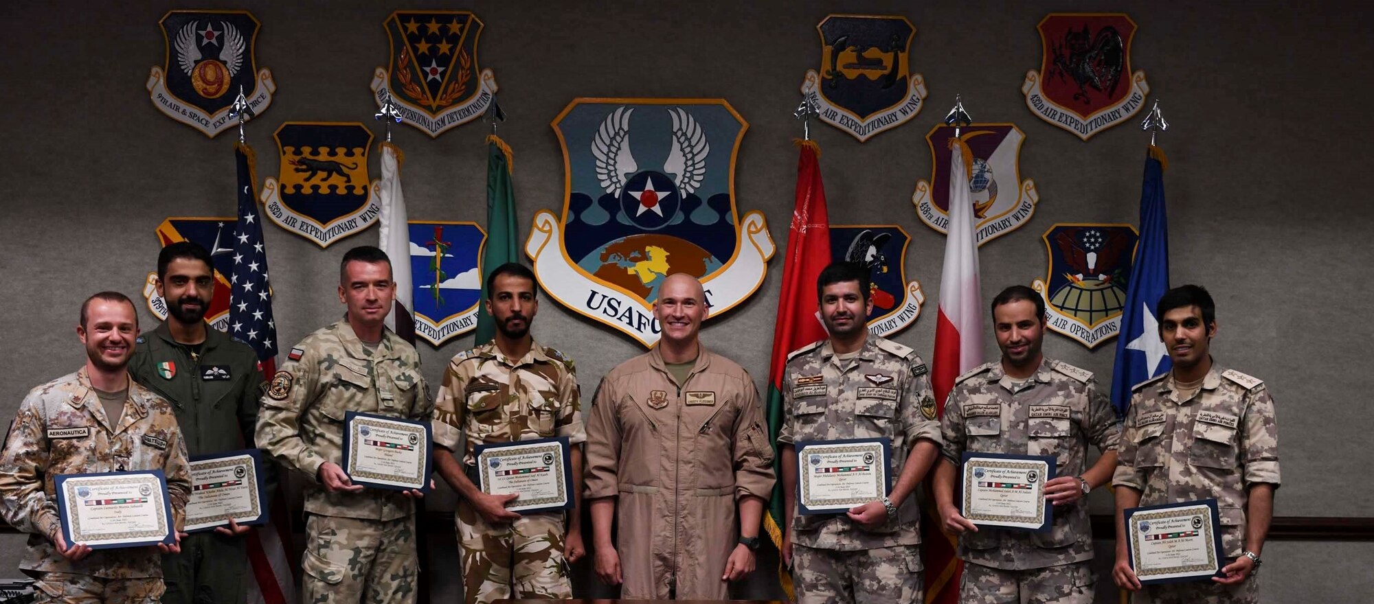 U.S. Air Force Maj. Christopher Fleissner, AFCENT/A5 air operations center training coordinator, and new graduates of the Air Defense Liaison Officer Course pose for a picture during a commencement ceremony at the Combined Air and Space Operations Center, June 24, 2021, Al Udeid Air Base, Qatar. The course hosted members from Gulf Cooperation Council nations and Jordan, and gives students a four-week compressed course in CAOC and regional air operations. (U.S. Air Force photo by Staff Sgt. Alexandria Lee)