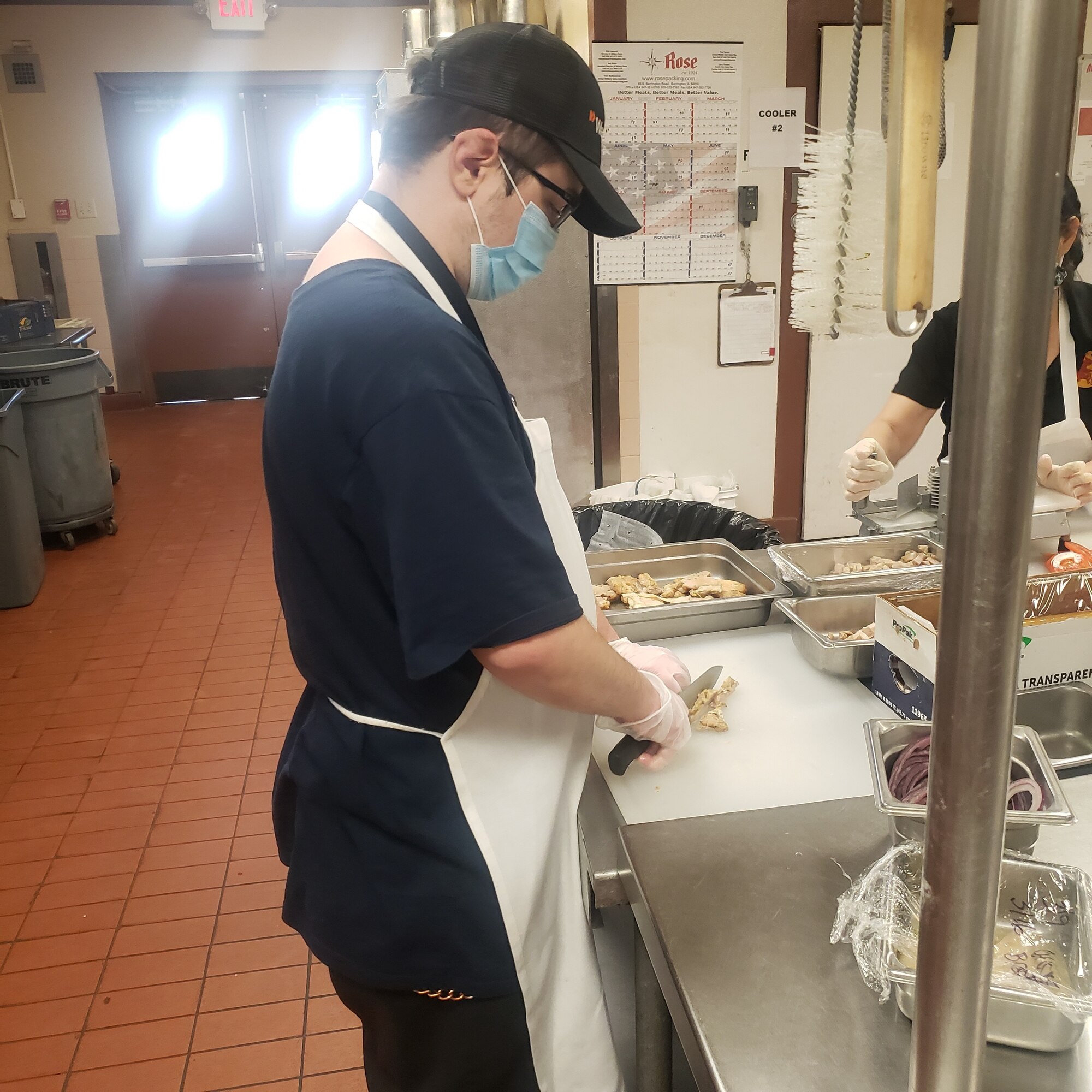 Jeffrey Mashburn, Project SEARCH intern, cuts grilled chicken for a salad, March 10, 2021, at Club Five Six, Luke Air Force Base, Arizona. Project SEARCH is a career-focused nine-month program, which allows interns to increase various skill sets such as communication, socialization, and teamwork while simultaneously increasing their confidence and hands-on work experience. Luke AFB has partnered with Project SEARCH for the past three years allowing interns to work side-by-side with U.S. Air Force personnel to build upon their skill sets, which aids the 56th Fighter Wing’s efforts of bolstering partnerships with the local community. (Courtesy photo)