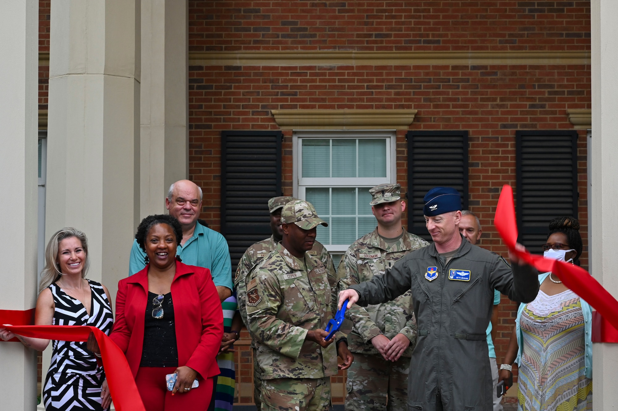 U.S. Air Force Col. Seth Graham (right), 14th Flying Training Wing commander, cuts a ribbon with Chief Master Sgt. Antonio Cooper, 14FTW command chief, signifying the grand opening of the new Welcome Center, July 20, 2021, on Columbus Air Force Base, Miss. Within the center new Team Blaze members will find a one stop shop for all their in-processing needs to include, Finance, Medical, Housing, Military Personnel Flight, and the Traffic Management Office. (U.S. Air Force photo by Airman 1st Class Jessica Haynie)