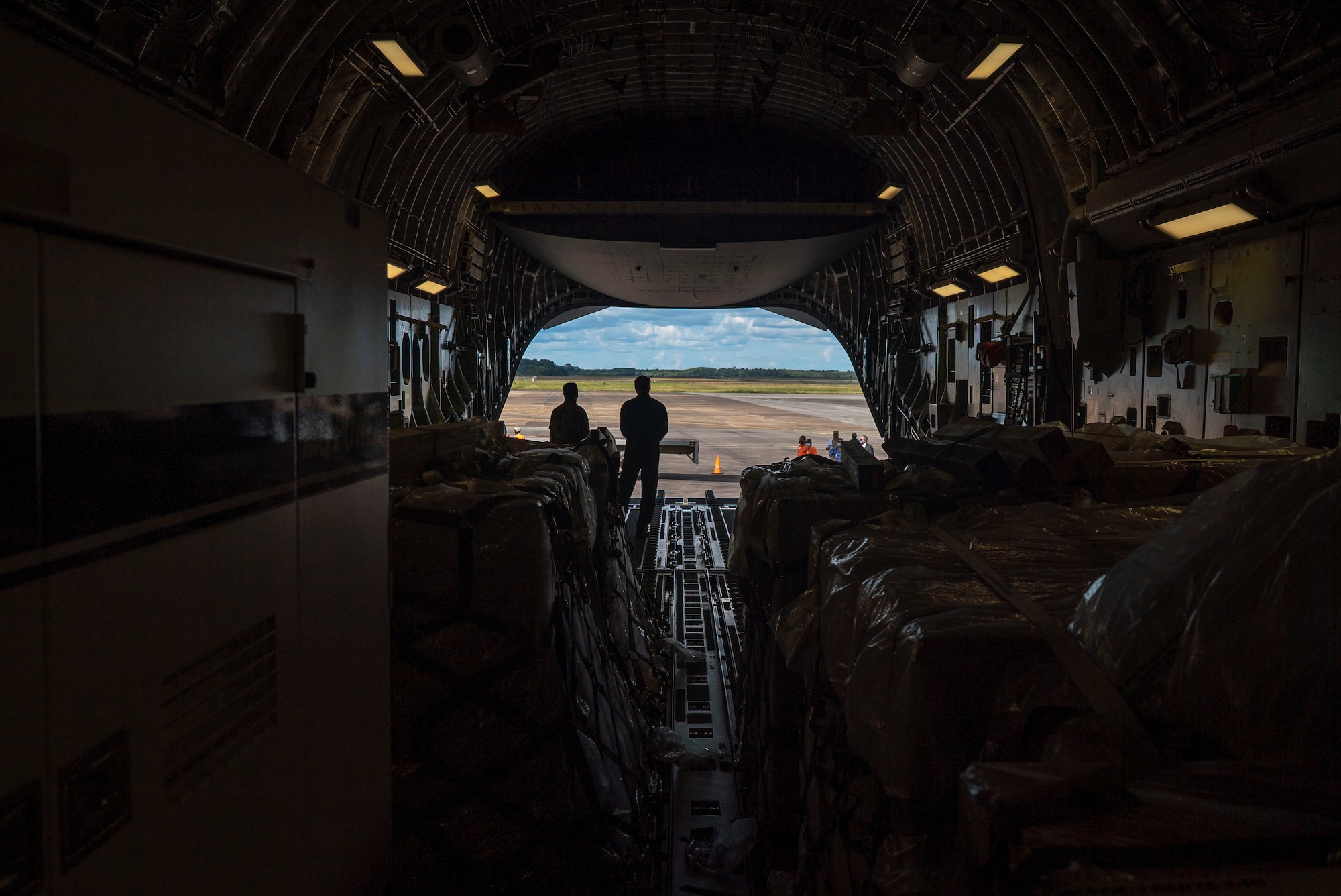 U.S. Air Force personnel and Surinamese locals unload field hospital equipment at Johan Adolf Pengel International Airport, Suriname, July 16, 2021.