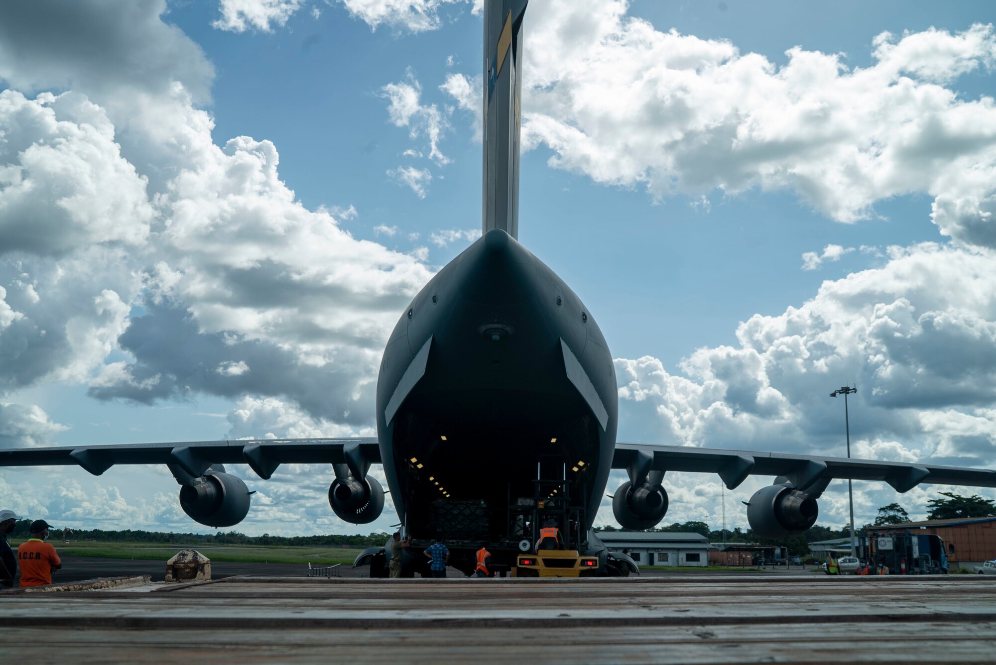 U.S. Air Force personnel and Surinamese locals unload field hospital equipment at Johan Adolf Pengel International Airport, Suriname, July 16, 2021.