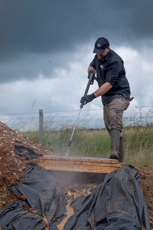 Gregory Ashcroft, squad lead for the American Veterans Archeological Recovery group, searches for remains of fallen service members during a B-24 Liberator excavation at Park Farm in Arundel, England, July 8, 2021. AVAR is conducting the dig in conjunction with the Defense POW/MIA Accounting Agency in an effort to recover those still missing in action. (U.S. Air Force photo by Senior Airman Koby I. Saunders)