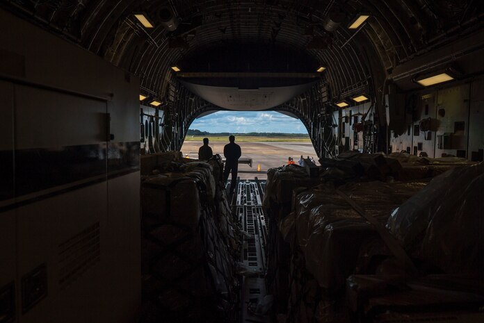 U.S. Air Force personnel and Surinamese locals unload field hospital equipment at Johan Adolf Pengel International Airport, Suriname, July 16, 2021.