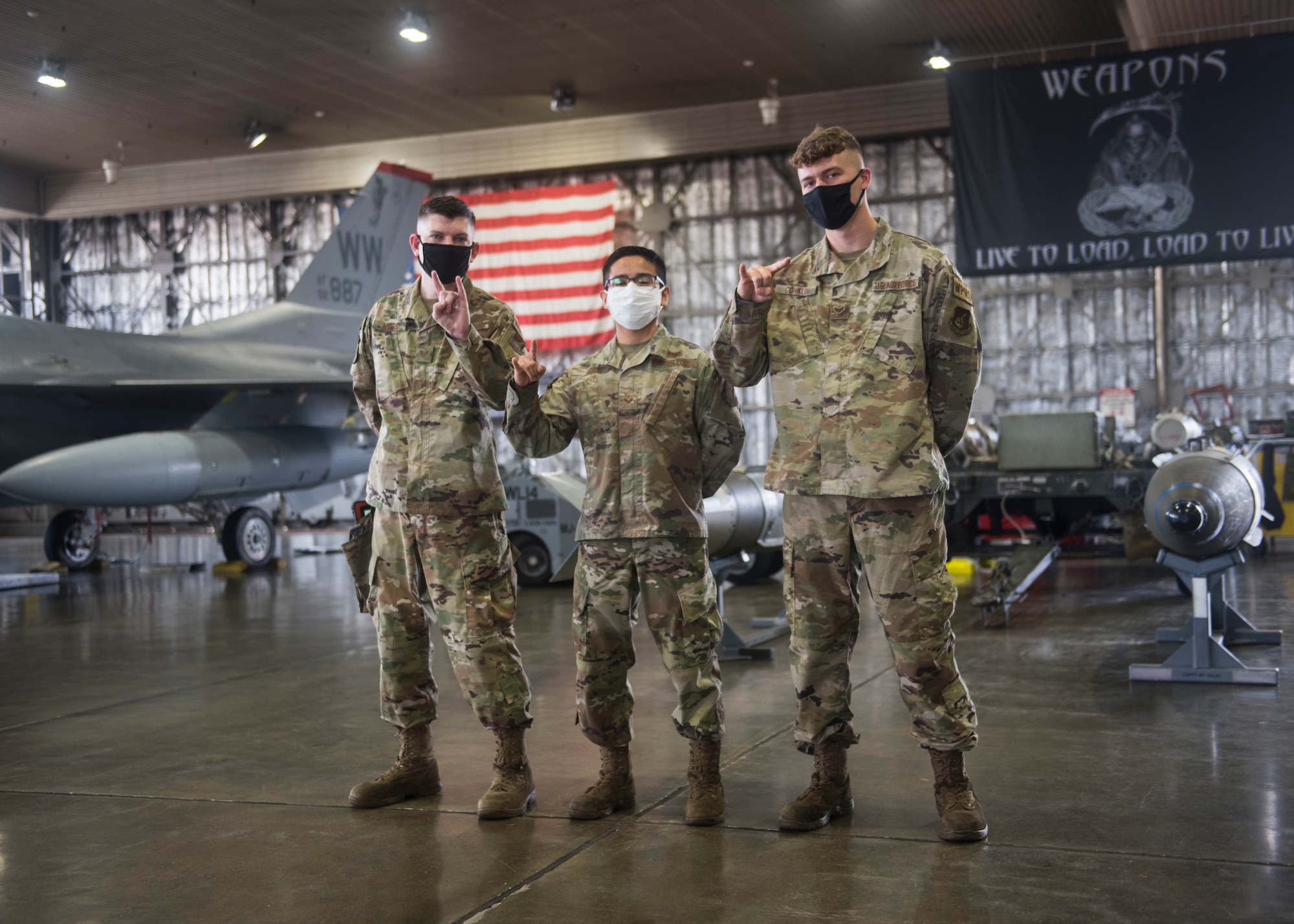 U.S. military members prepares munitions to be loaded and ready for an F-16.