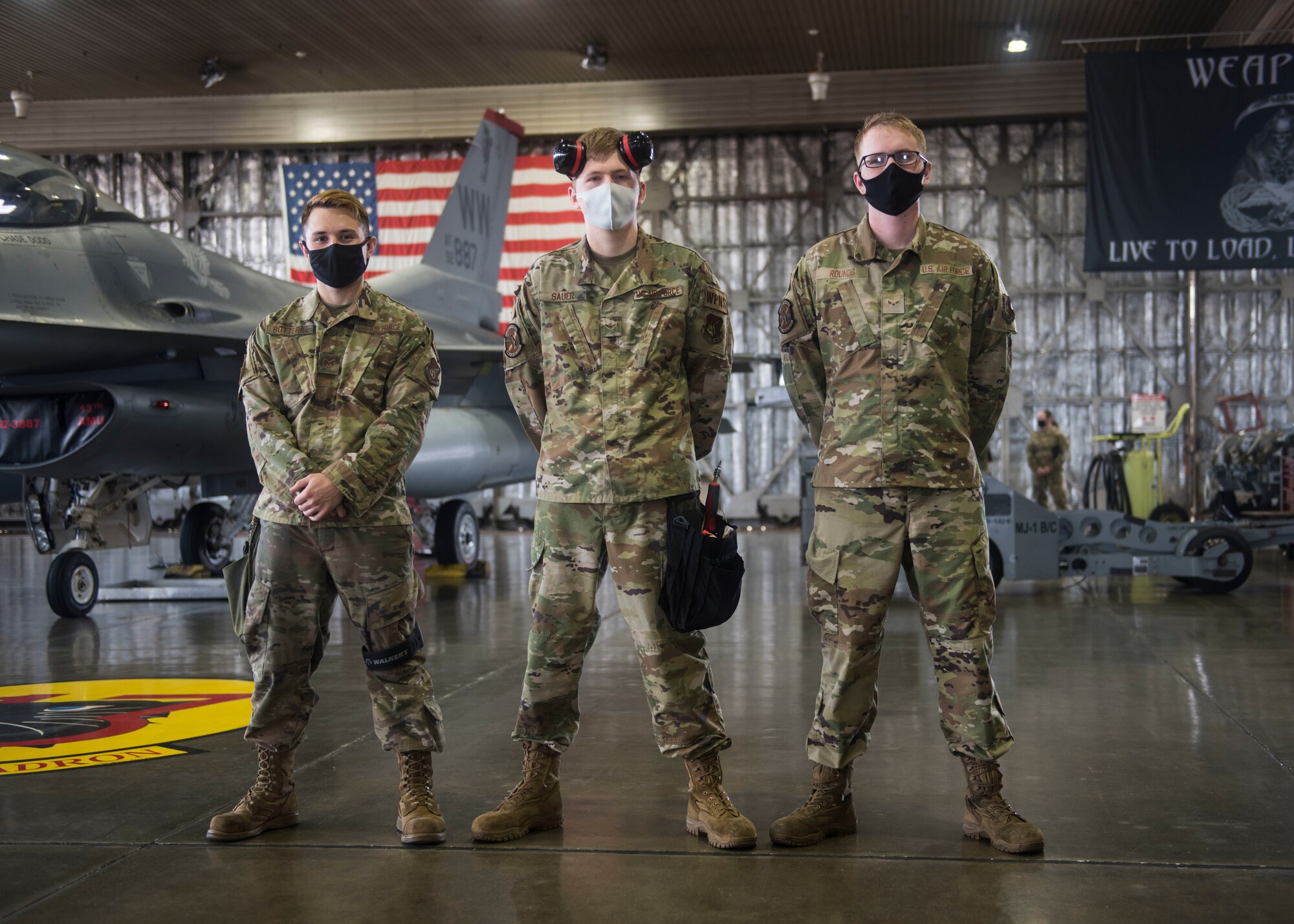 U.S. military members prepares munitions to be loaded and ready for an F-16.