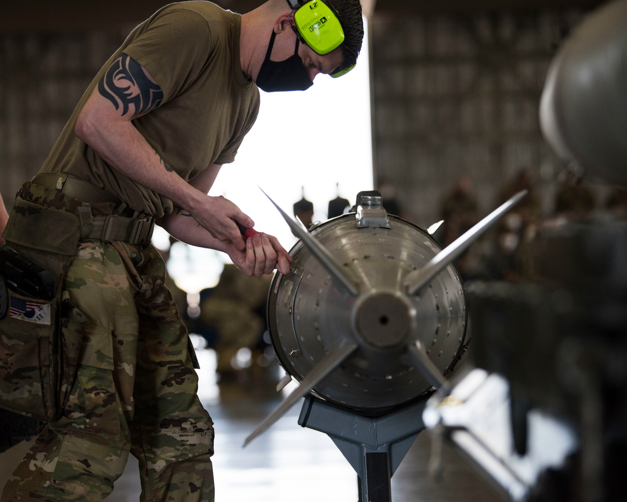 U.S. military members prepares munitions to be loaded and ready for an F-16.