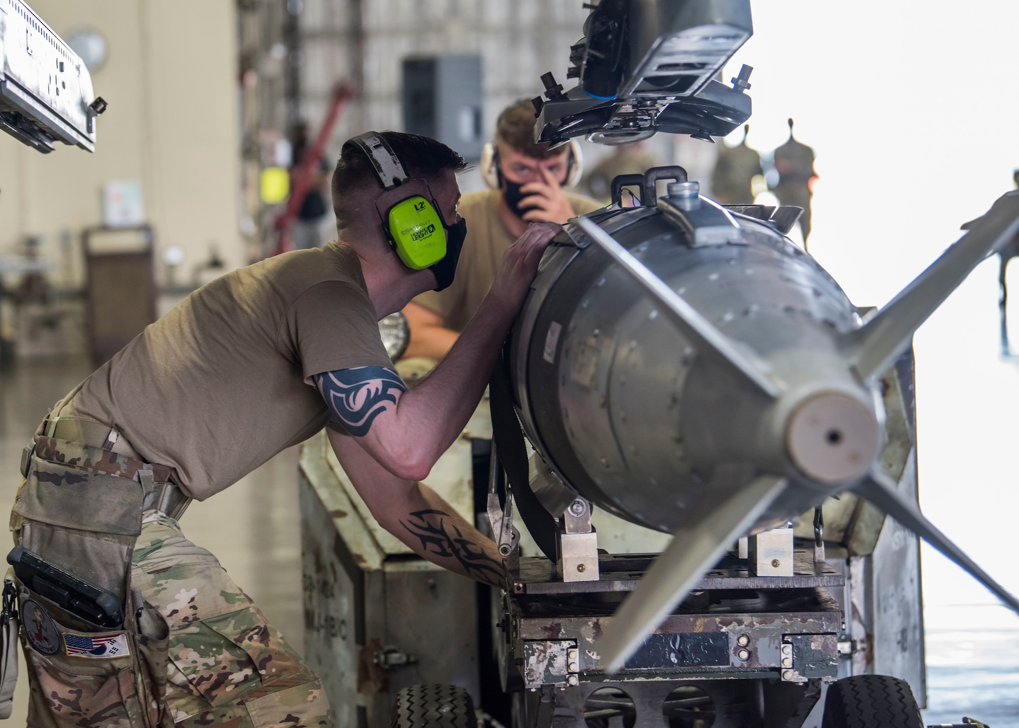 U.S. military members prepares munitions to be loaded and ready for an F-16.