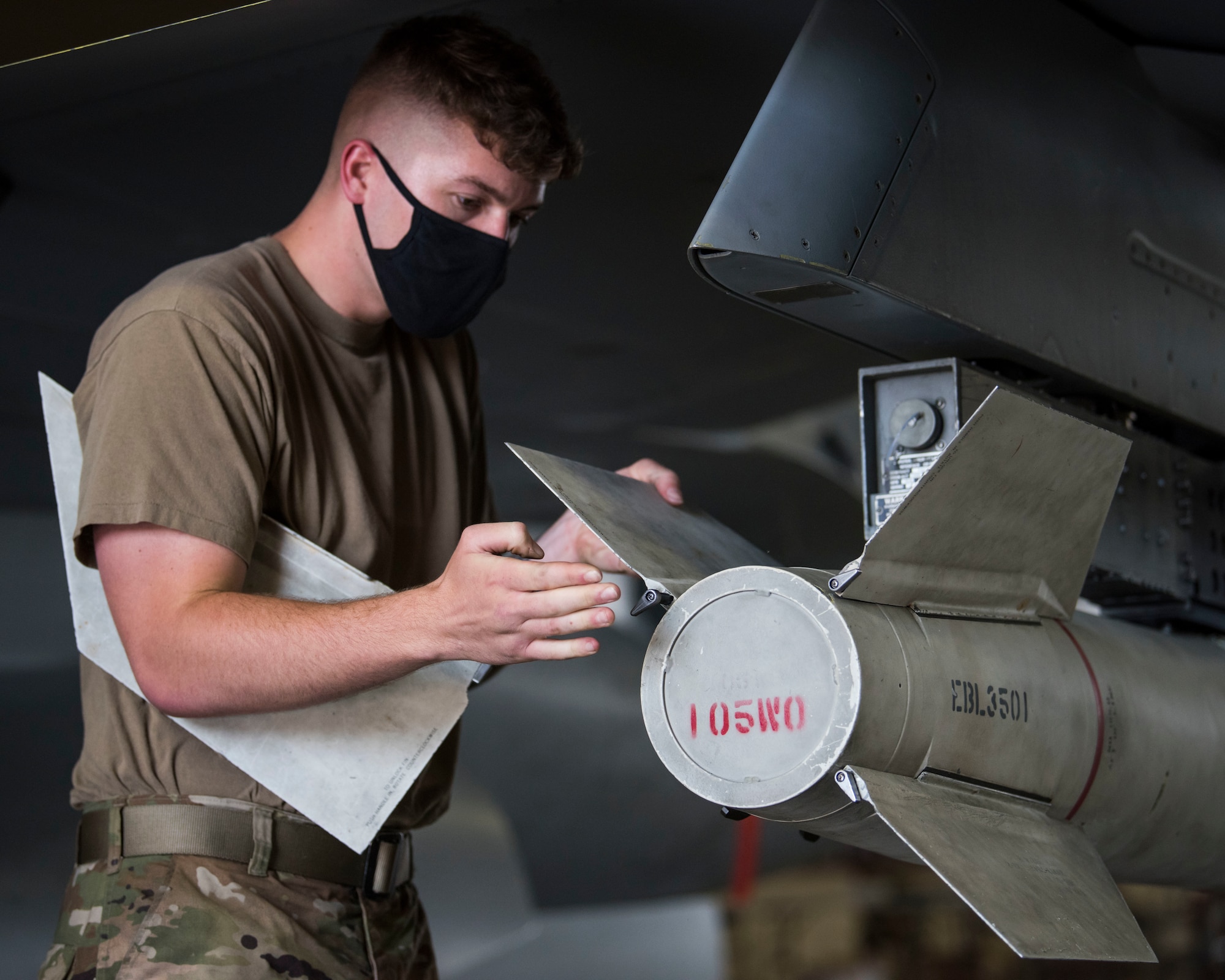 U.S. military member prepares munitions to be loaded and ready for an F-16.